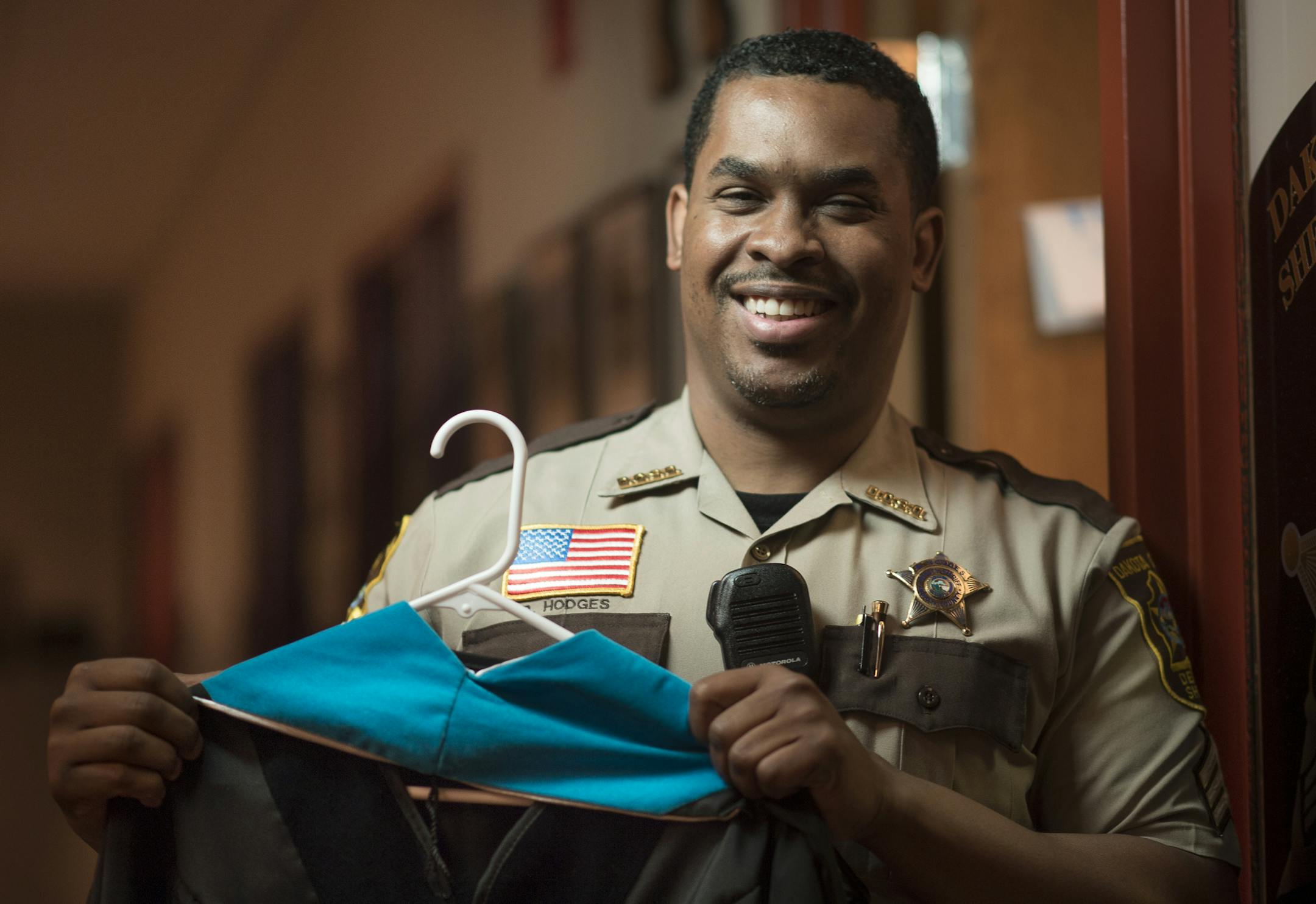 Sgt. Booker Hodges, with the Dakota County Sheriff's Office, was photographed outside his office on Tuesday afternoon holding his graduation gown. ] Aaron Lavinsky • aaron.lavinsky@startribune.com Booker Hodges, a Dakota County sheriff's office commander, recently became the first officer of color to receive a doctorate from Hamline University. Hodges emerged from a trying childhood in north Minneapolis. His mother died when he was 12 after years of abuse by his father, and a classmate wa