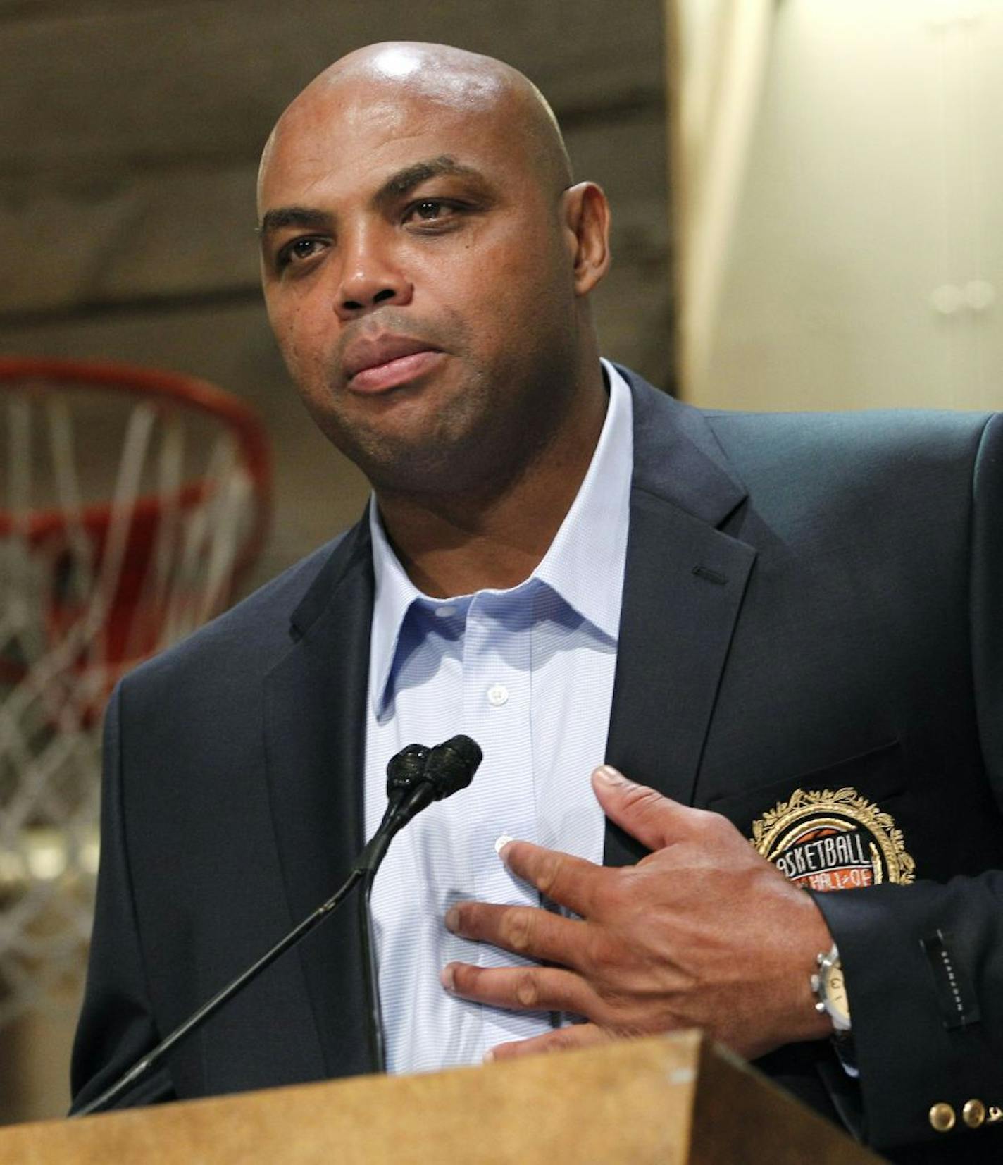 FILE - in this Aug. 13, 2010 file photo, Basketball Hall of Fame inductee Charles Barkley, representing the 1992 USA Olympic "Dream" Team, pats his heart as he speaks during the enshrinement news conference at the Hall of Fame Museum in Springfield, Mass. One result of the NCAA's new deal with CBS and Turner Sports to televise the men's basketball tournament is that TNT NBA announcers such as Charles Barkley will be now analyzing college games.