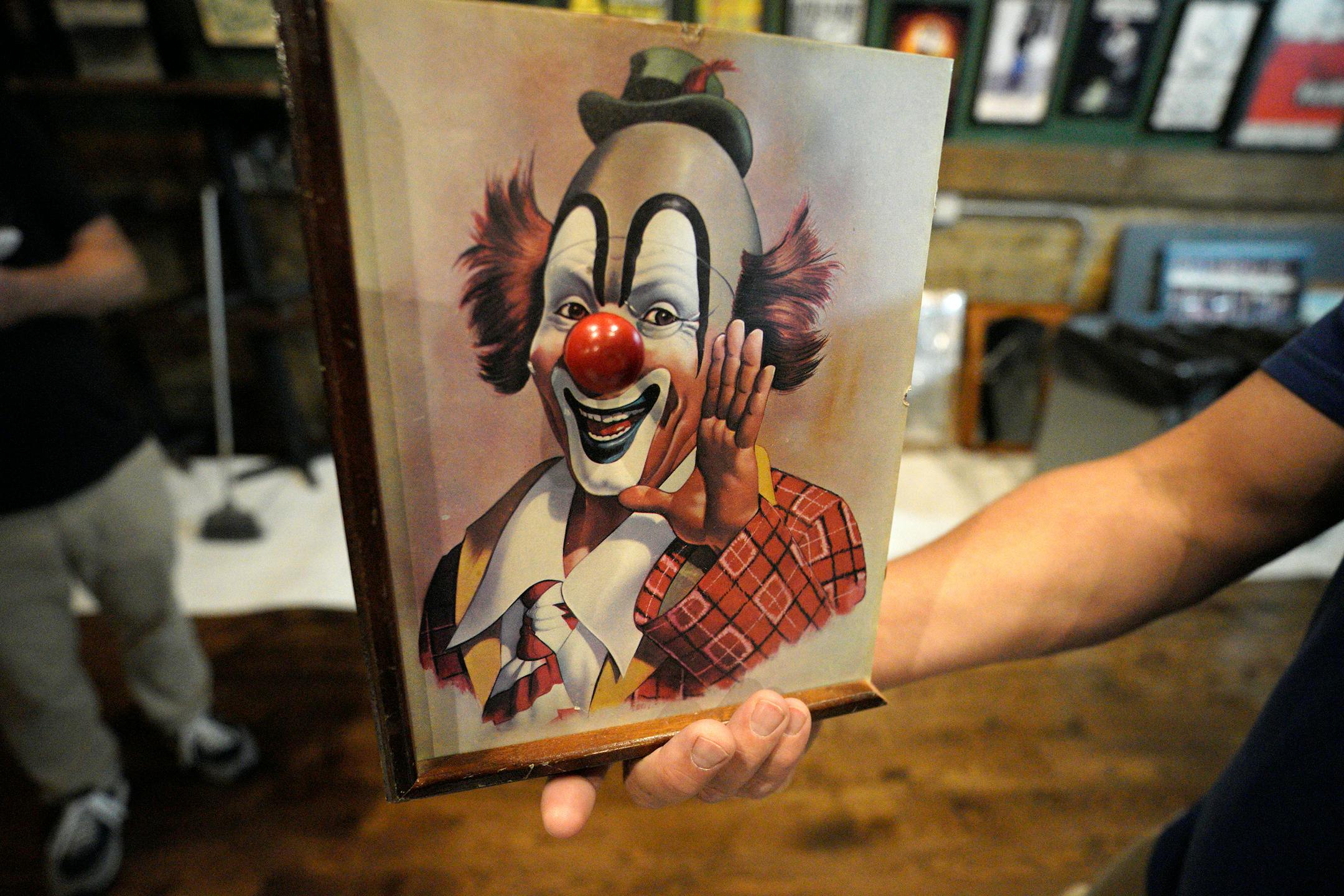 This clown picture with big red nose was found to actually be a music box if you turn the nose to wind it up.
