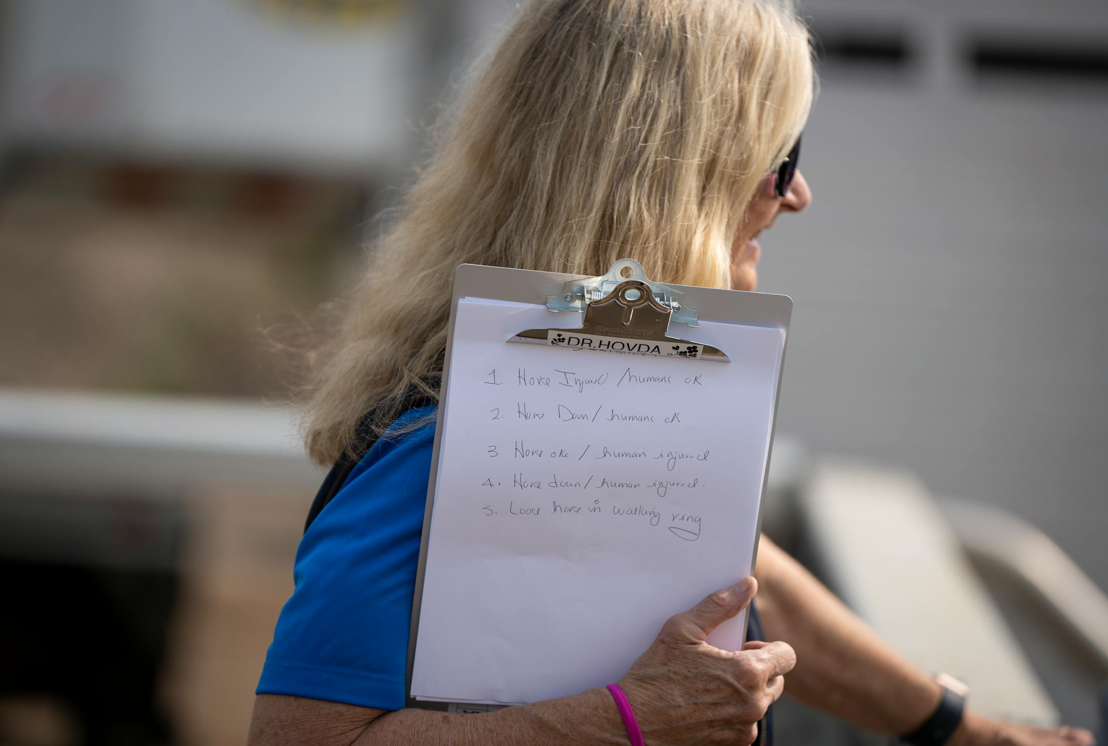 Dr. Lynn Hovda carries a clipboard with a list of Horse Racing Integrity and Safety Authority (HISA)-mandated preseason drills they must perform that day at Canterbury Park in Shakopee, Minn.