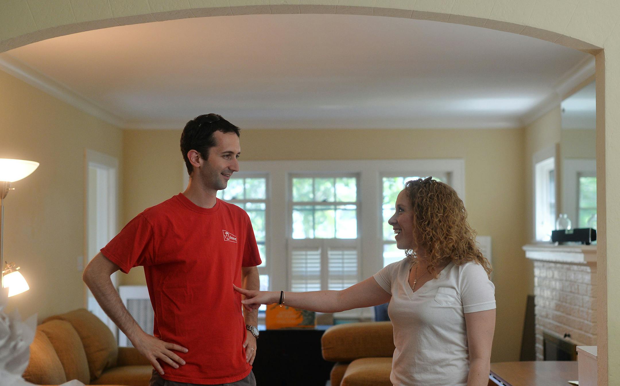 From left, Brian Burke laughed with his wife, Jennifer Burke after the moving truck left their new home. Jennifer and Brian Burke, first-time buyers, moved into their house in Minneapolis, Minn., on Sunday July 19, 2015. ] RACHEL WOOLF &#x2211; rachel.woolf@startribune.com