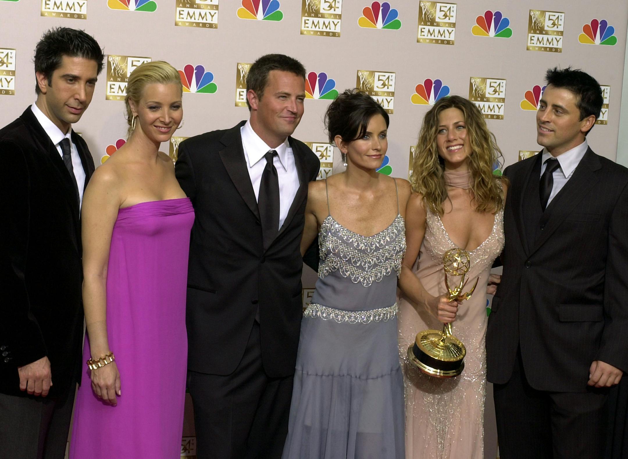 FILE - In this Sept. 22, 2002 file photo, the stars of "Friends," from left, David Schwimmer, Lisa Kudrow, Matthew Perry, Courteney Cox Arquette, Jennifer Aniston and Matt LeBlanc pose after the show won outstanding comedy series at the 54th Annual Primetime Emmy Awards, at the Shrine Auditorium in Los Angeles. If you’re a “Friends” superfan, there are lots of ways to celebrate the show’s 25th anniversary on Sept. 22, 2019. Warner Bros. has partnered with a range of c