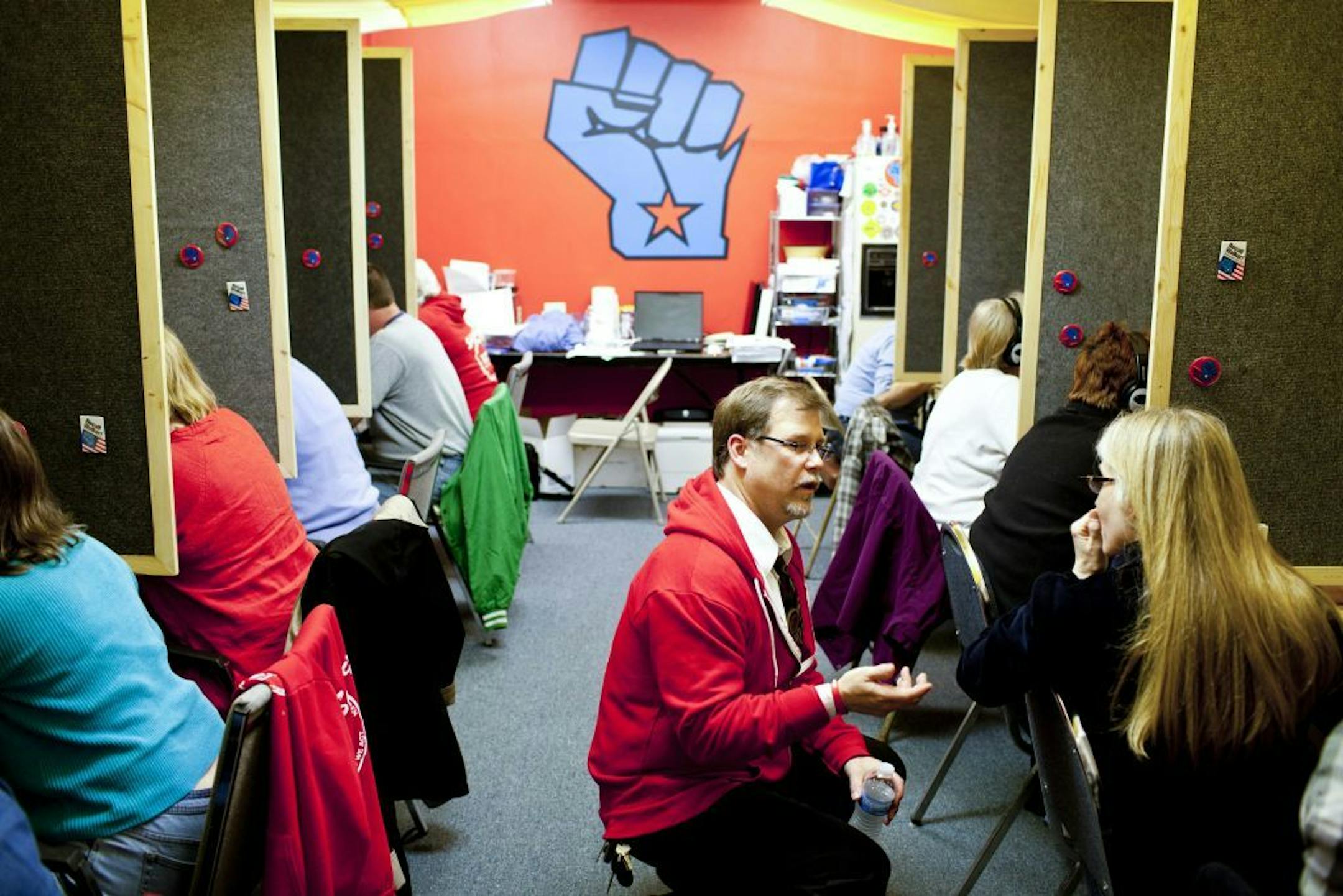 Jeff Knight, center, talks with a volunteer at a union phone bank in Madison, Wis., April 25, 2012. The vote on recalling Wisconsin Gov. Scott Walker has become a rallying point for unions and business interests that oppose them, but it is only a warm-up.