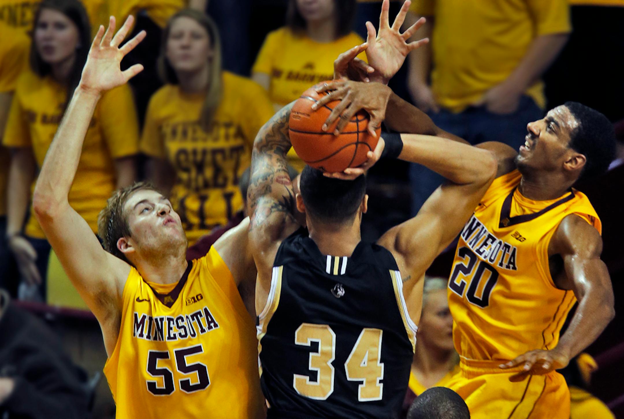 Gophers vs. Wofford basketball. Minnesota defenders Elliott Eliason (55) and Austin Hollins blocked Wofford's Lee Skinner's field goal attempt.