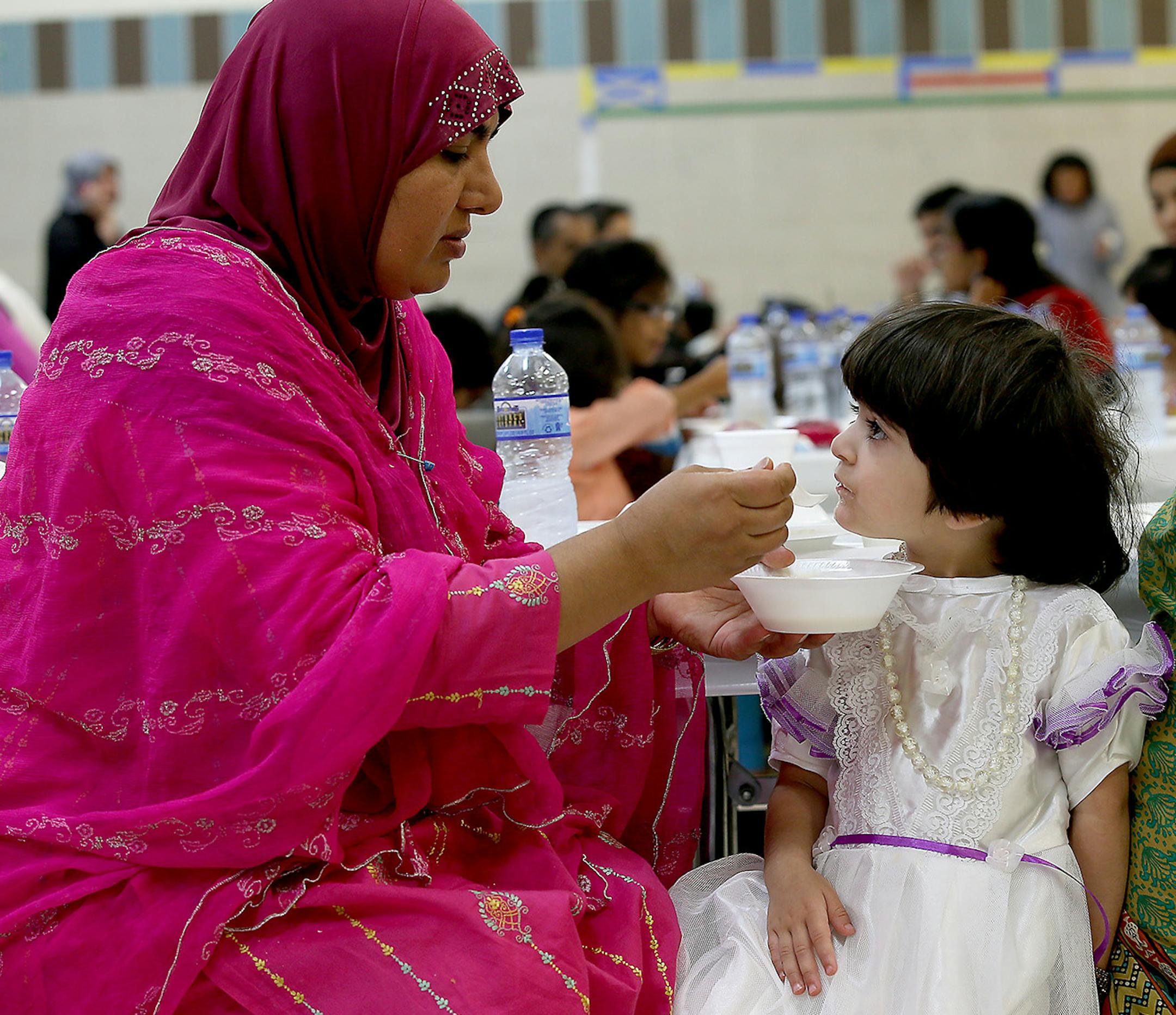 Tahira Hassan fed her daughter Simra Hassan, 3, a traditional Middle Eastern dish at the Islamic Center’s community breakfast.