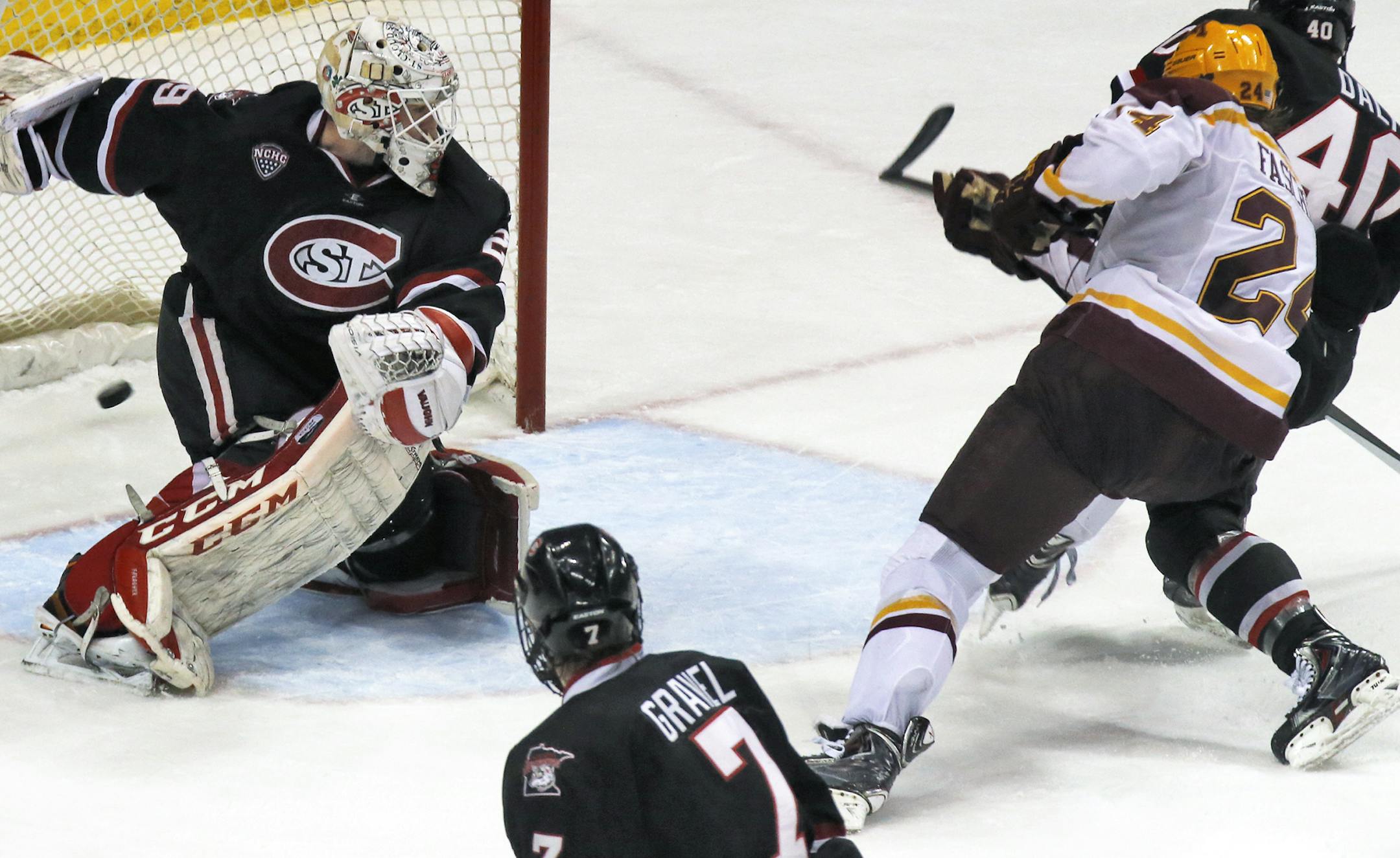 Minnesota Gophers vs. St. Cloud State University (SCSU). Minnesota's Hudson Fasching (24) sent the puck flying past SCSU goalie Ryan Faragher in 2nd period action. (MARLIN LEVISON/STARTRIBUNE(mlevison@startribune.com)