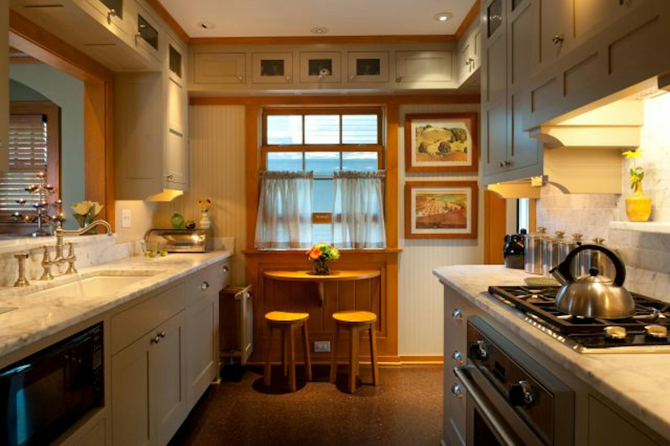 The kitchen includes a tiny, fold-out breakfast table. The stools pack away into a custom, rolling cabinet.