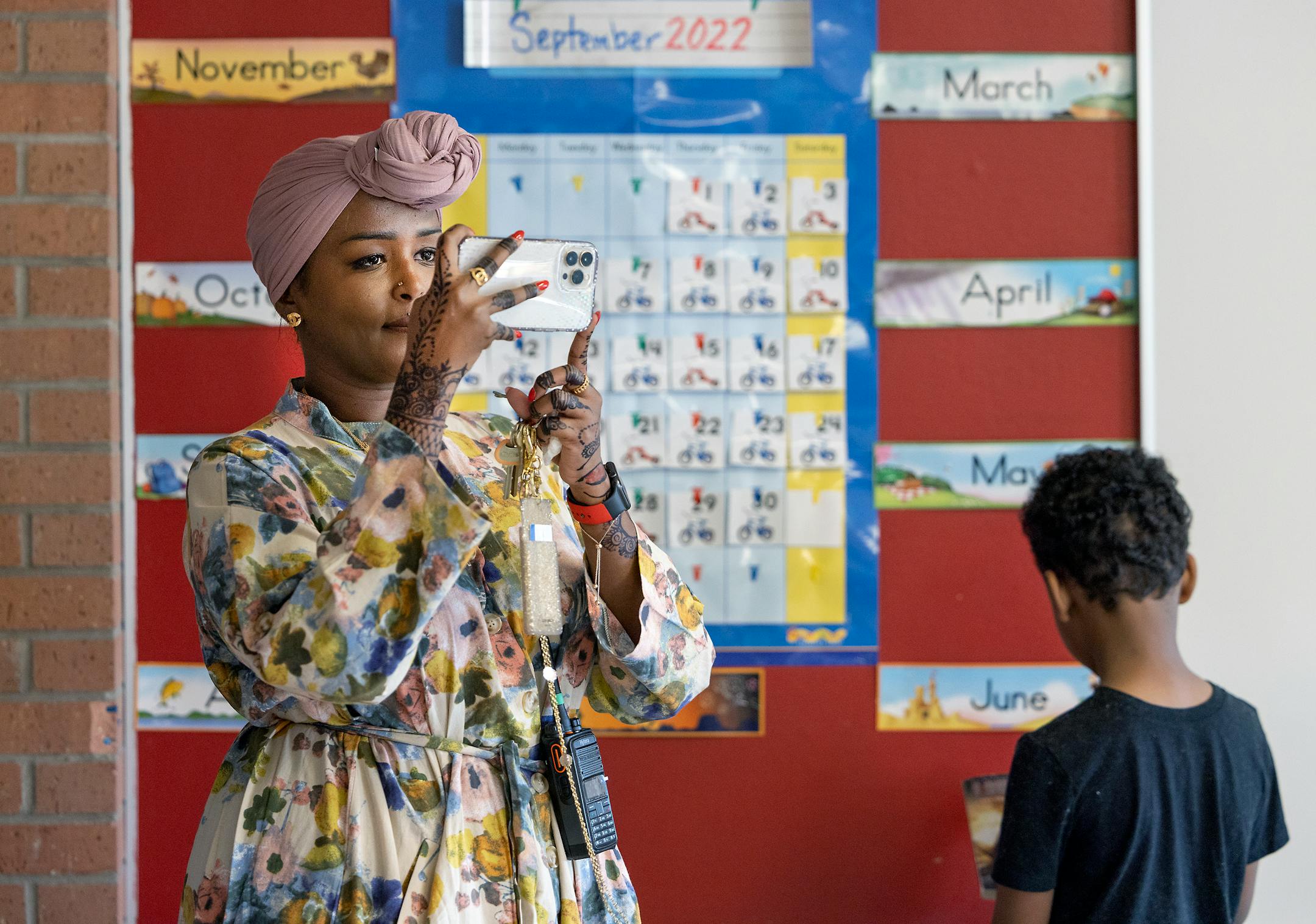 Gideon Pond Elementary Principal Salma Hussein grabs some photos from her cell phone as she visits each classroom in Burnsville.