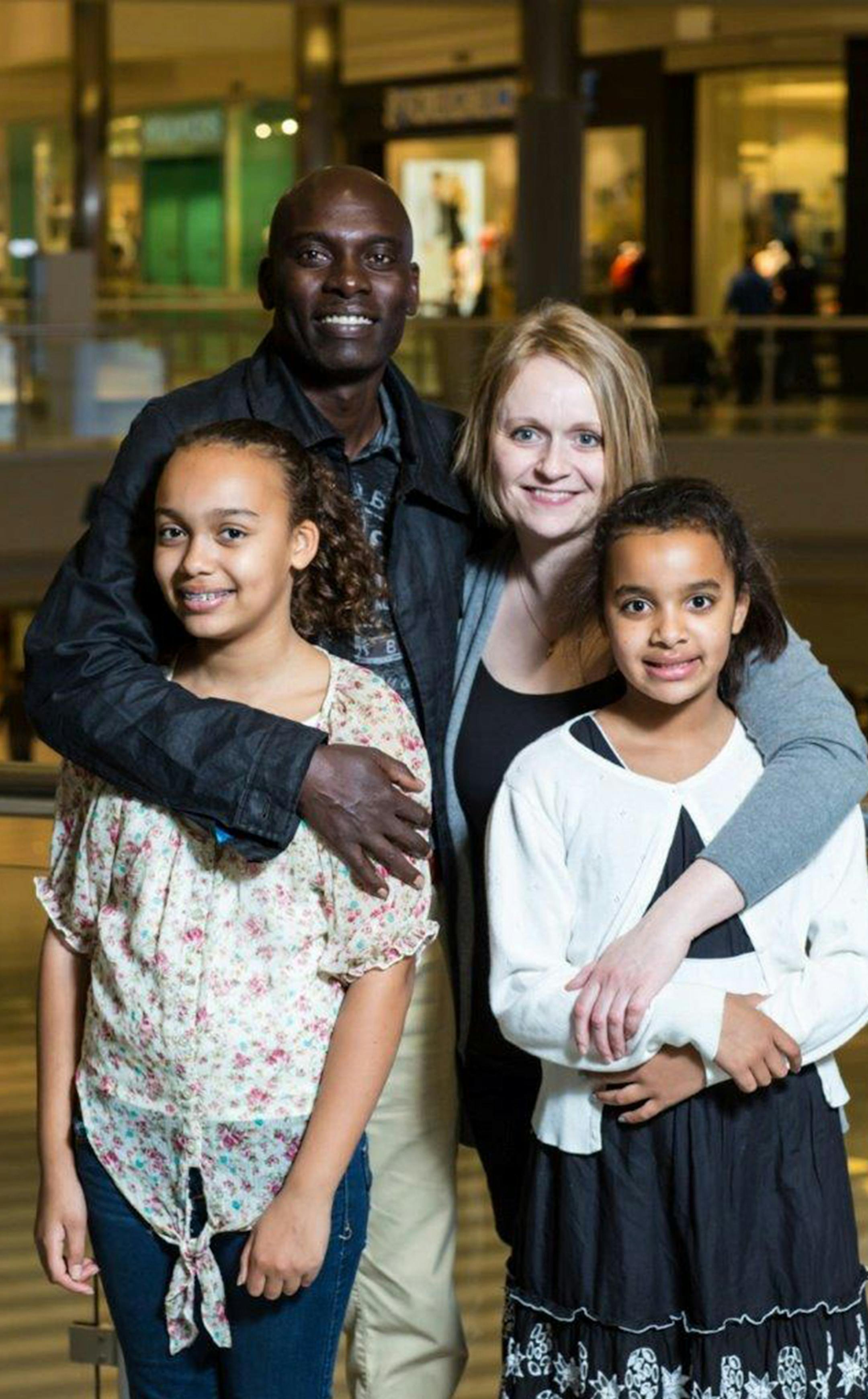 George Mayaka, 45, the Vom Fass Maple Grove co-owner, with his co-owner and wife Jenny Mayaka and his daughters.