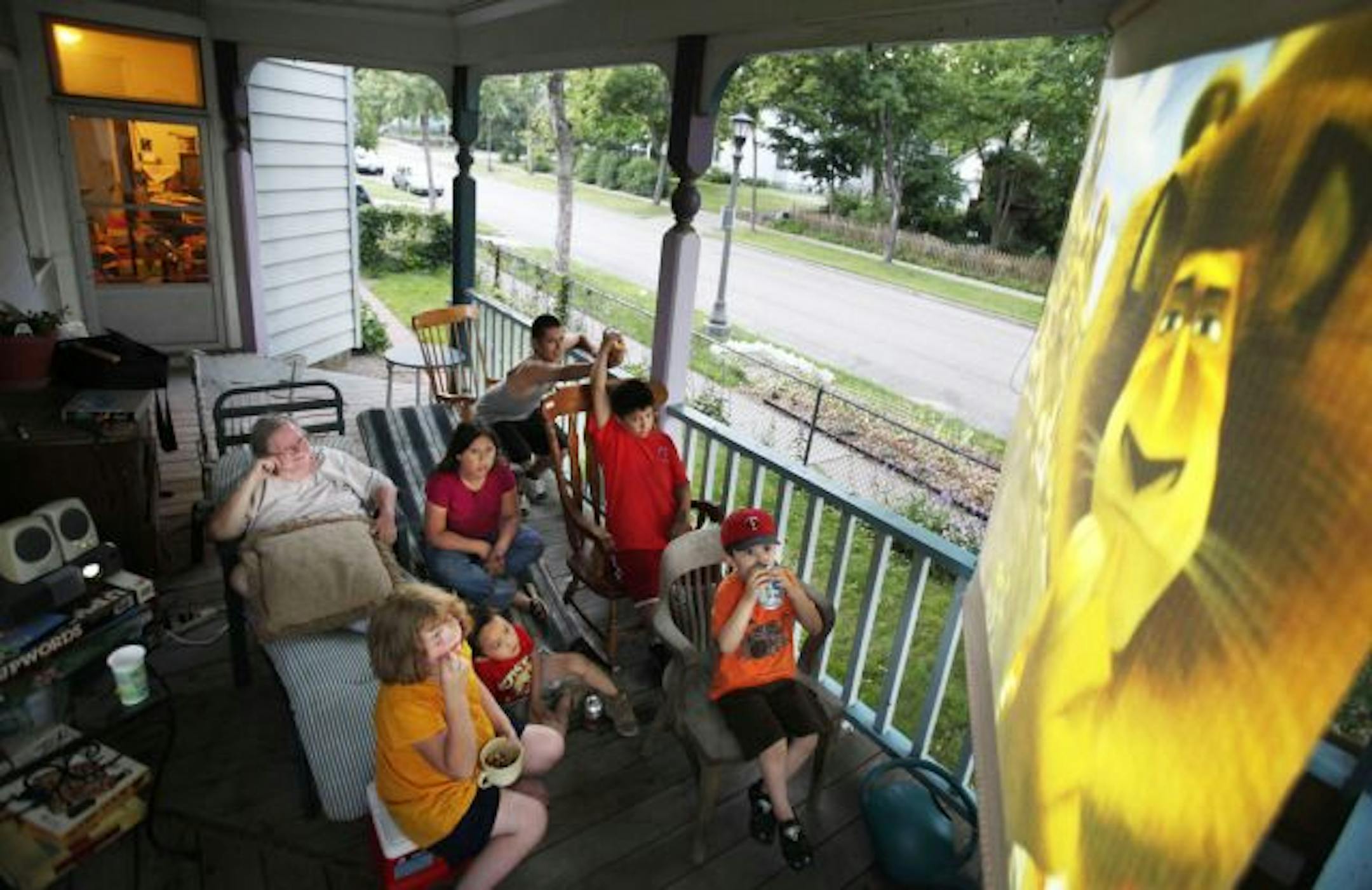 Pass the popcorn, please: Sage Holben, left, and some young Dayton's Bluff neighbors watch "Madagascar 2" on her porch. "Change happens when people come together," Holben says.