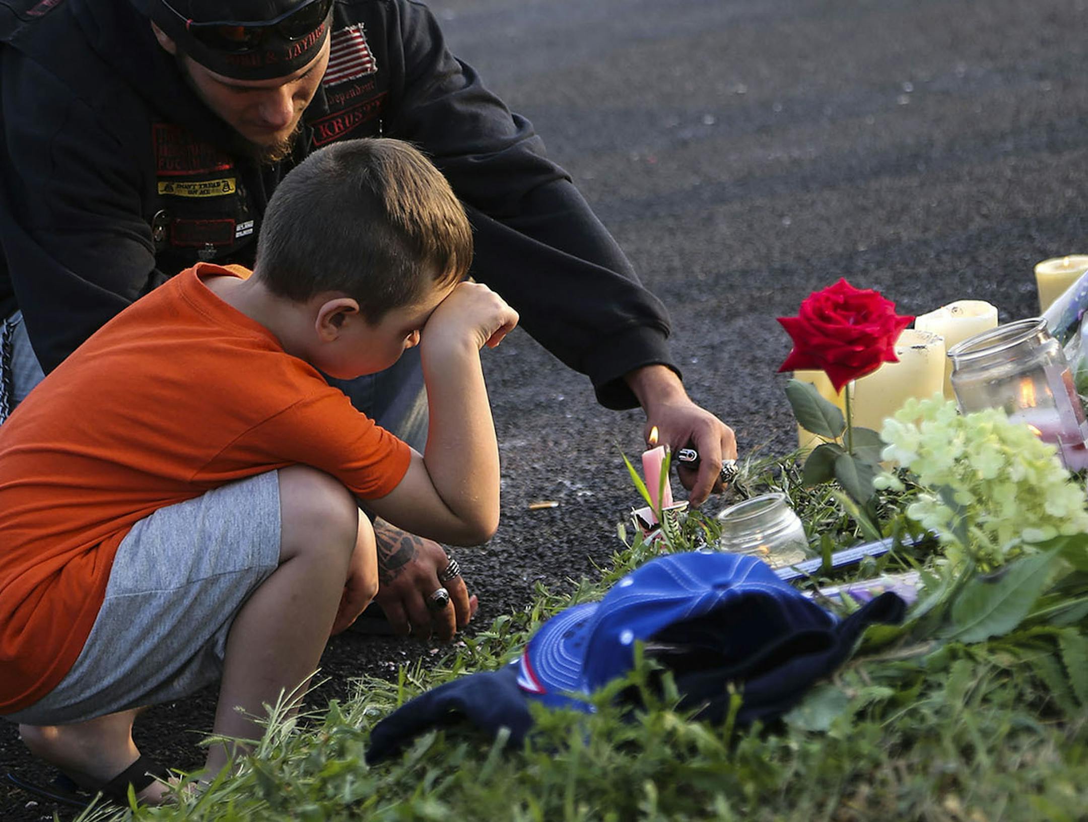 Nicholas Hochule, 7, of West St. Paul, brought a candle to the memorial site near his slaying and got help from Shawn Sherman of St. Paul, who lit the candle for Nicholas.