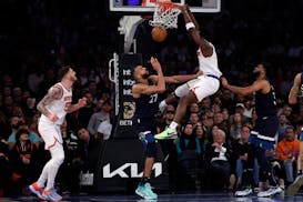 New York Knicks forward OG Anunoby dunks the ball over Minnesota Timberwolves center Rudy Gobert (27) during the first half of an NBA basketball game,