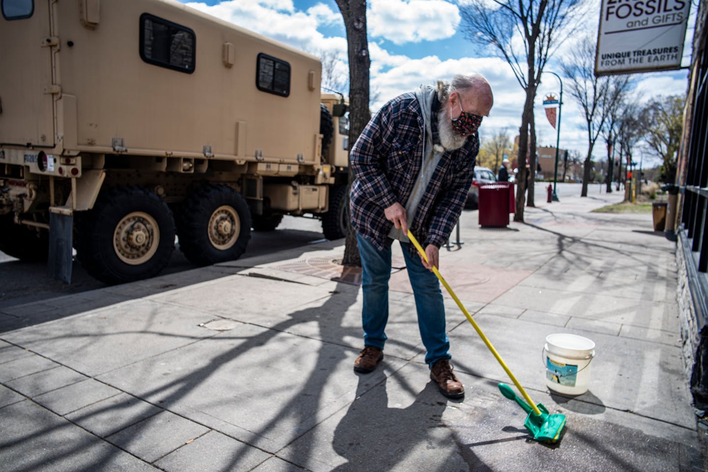 In Uptown Minneapolis on Wednesday, April 21, 2021 Kent Cooper cleaned up the sidewalk in front of ZRS Fossils &amp; Gifts where he works as the National Guard kept an eye on businesses a day after Derek Chauvin was convicted for the murder of George Floyd.] RICHARD TSONG-TAATARII ¥ Richard.Tsong-Taatarii@startribune.com