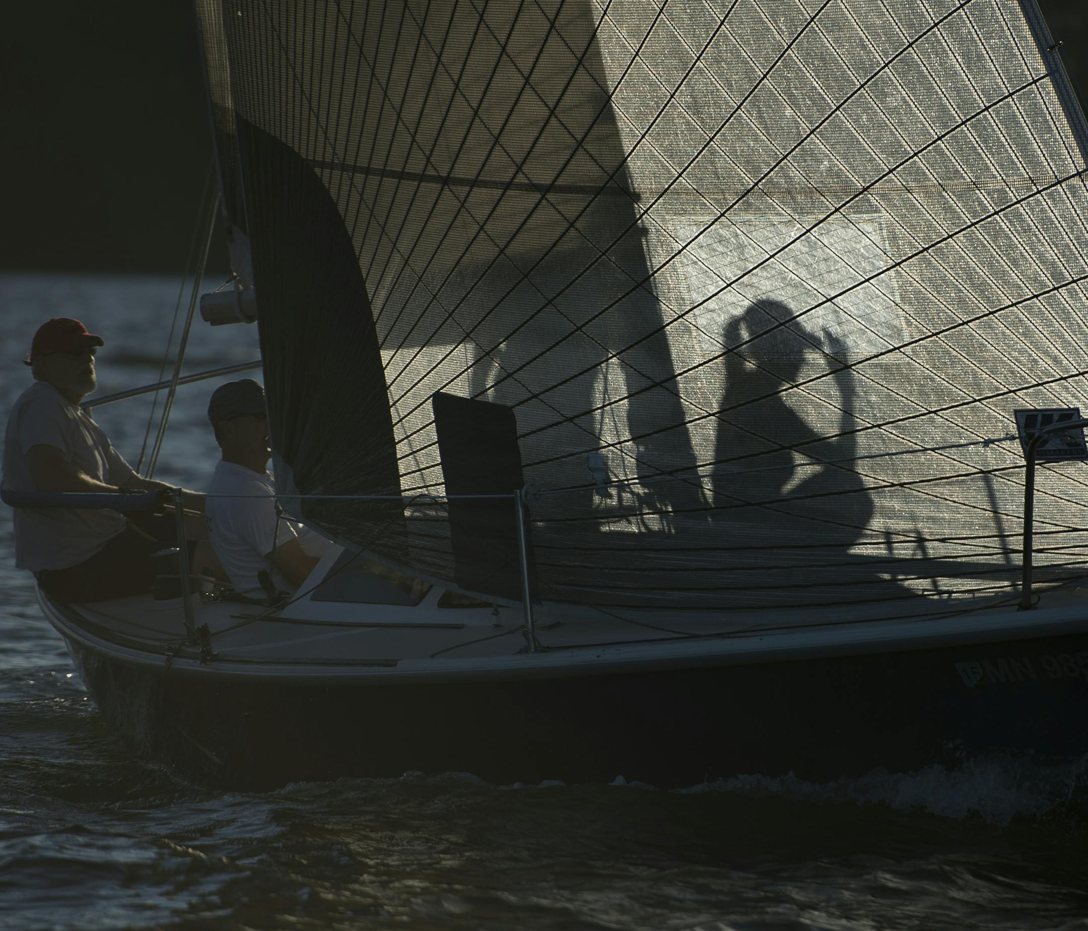 The crew of the Capri 25 Class sailboat, the "Catapult" was silhouetted by the setting sun after crossing the finish Thursday night. ] Aaron Lavinsky &#x2022; aaron.lavinsky@startribune.com We feature the Wayzata Yacht Club, in its 50th year, and focus on a weeknight of racing involving upward of 200 boats on Lake Minnetonka. Photographed Thursday, June 25, 2015.
