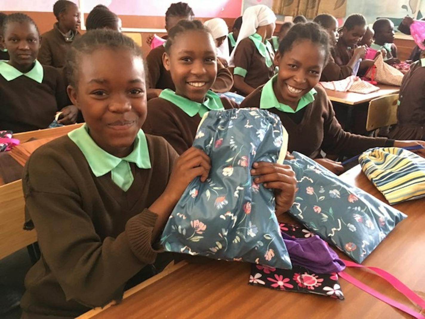 Girls in Nairobi, Kenya show off their new kits from the Twin Cities team of Days For Girls in October 2018.