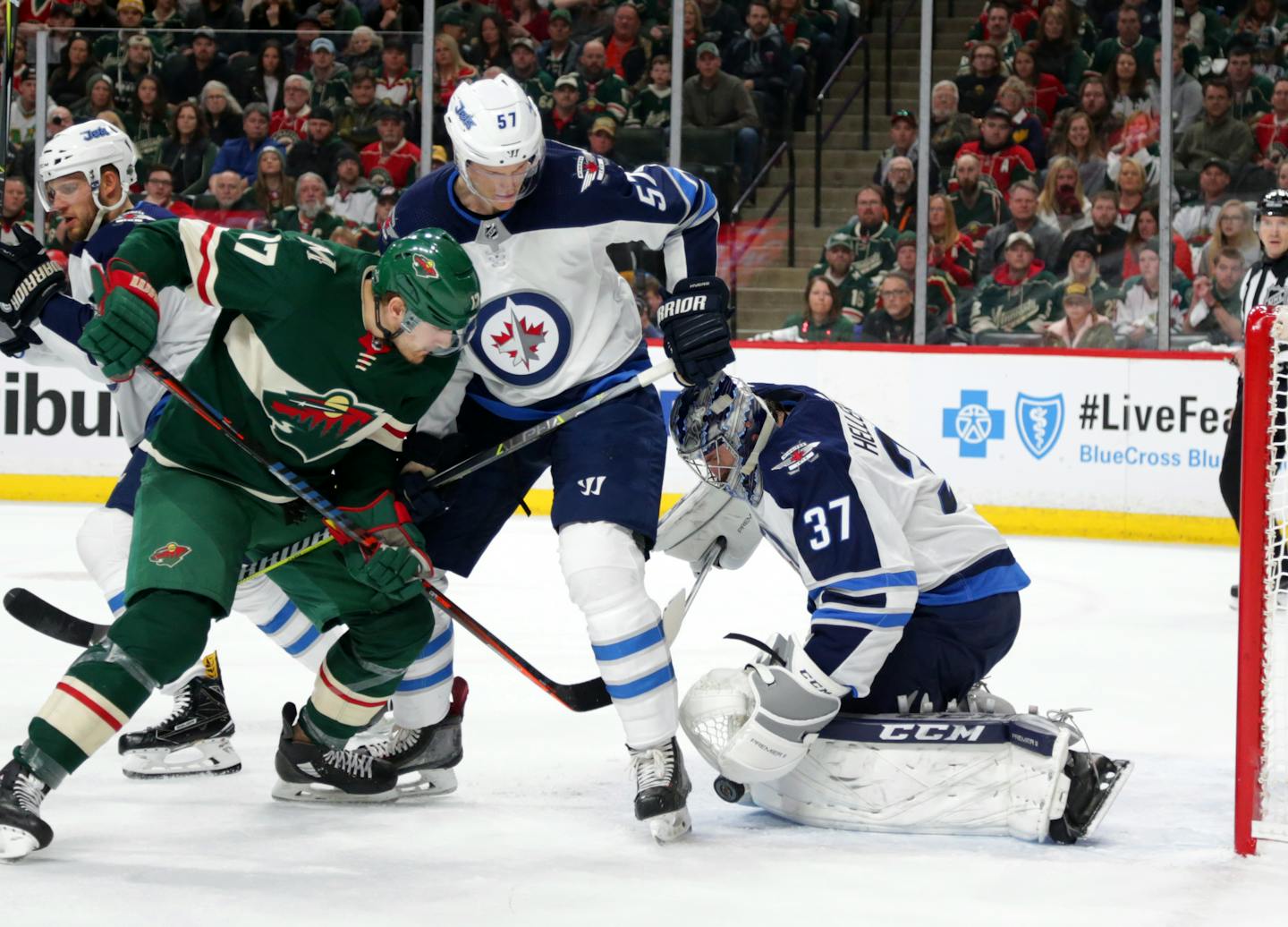 Minnesota Wild left wing Marcus Foligno (17) is stopped by Winnipeg Jets goalie Connor Hellebuyck (37) with defensive help from Jets' defenseman Tyler Myers (57) in the first period of Game 3 Sunday.