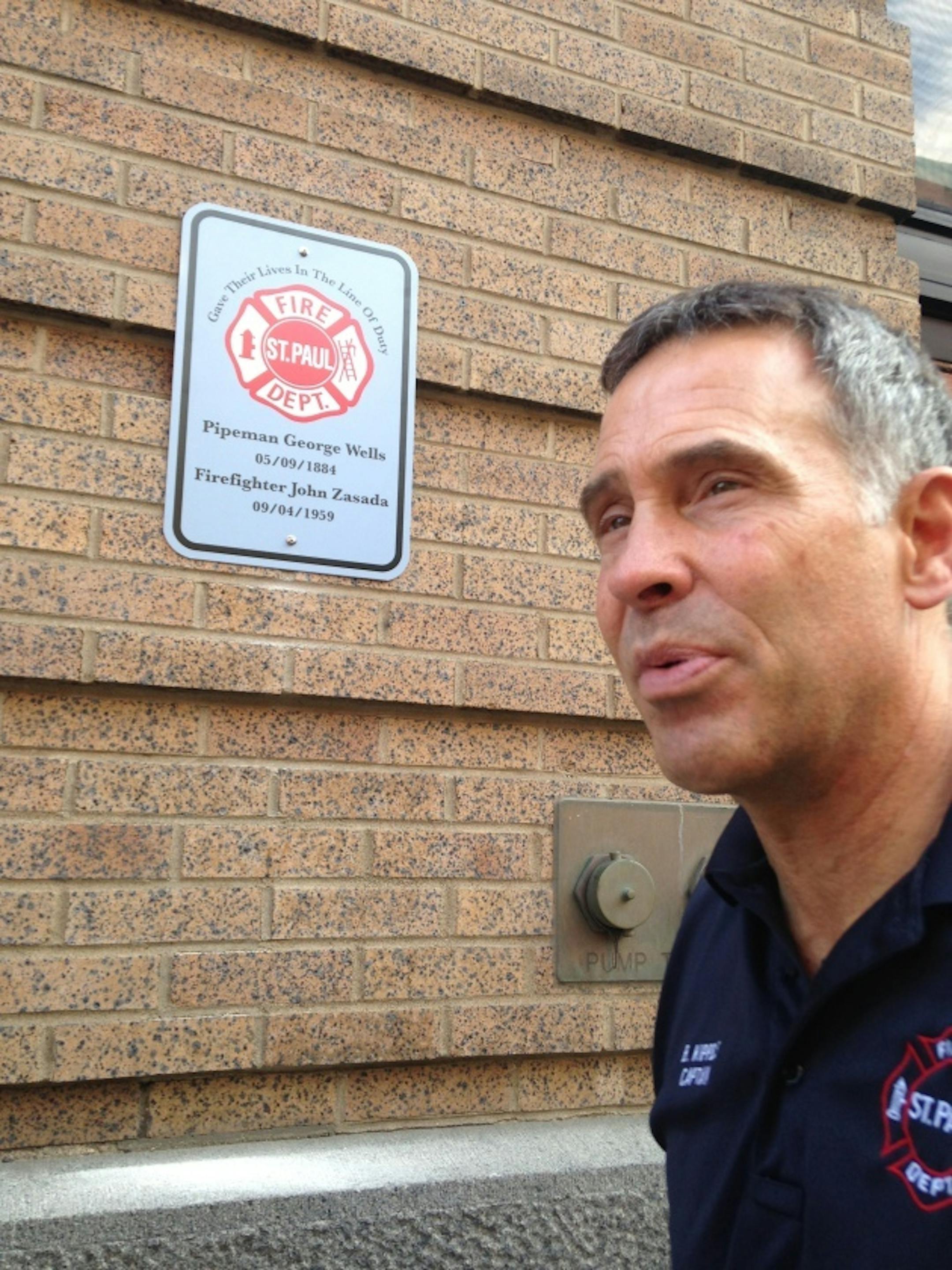 St. Paul fire Captain Bob Kippels talks about the memorial project while standing next to the first sign.