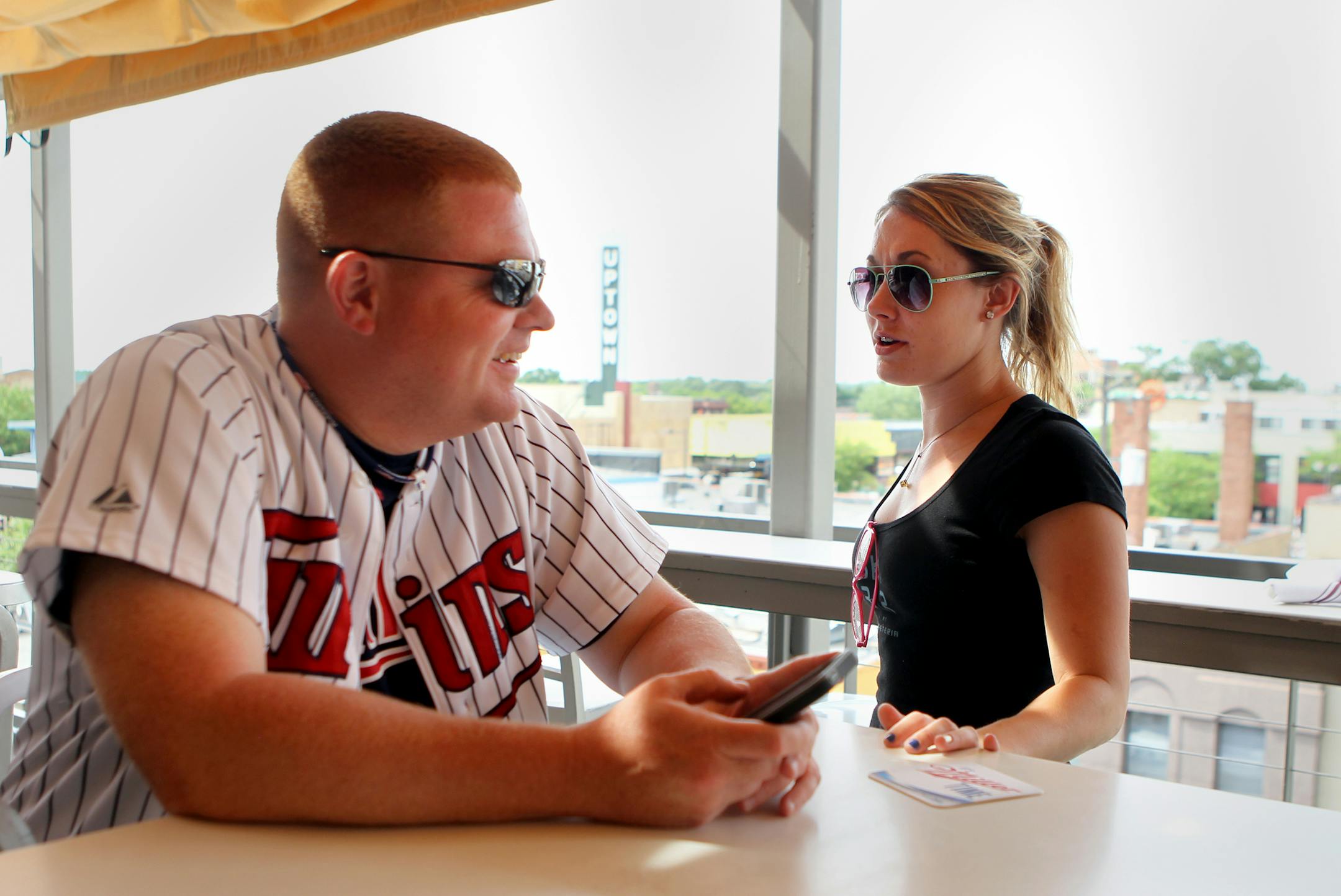 Seasonal server Bailey Frederickson takes a drink order for Nick Fritzen, of Shakopee, on the sky bar at Uptown Cafeteria in Minneapolis, Minn., on Thursday, June 20, 2013. Minnesota added 8,400 jobs in May, many in the hospitality industry when the weather became nicer and people began to go out more. ] (ANNA REED/STAR TRIBUNE) anna.reed@startribune.com (cq)