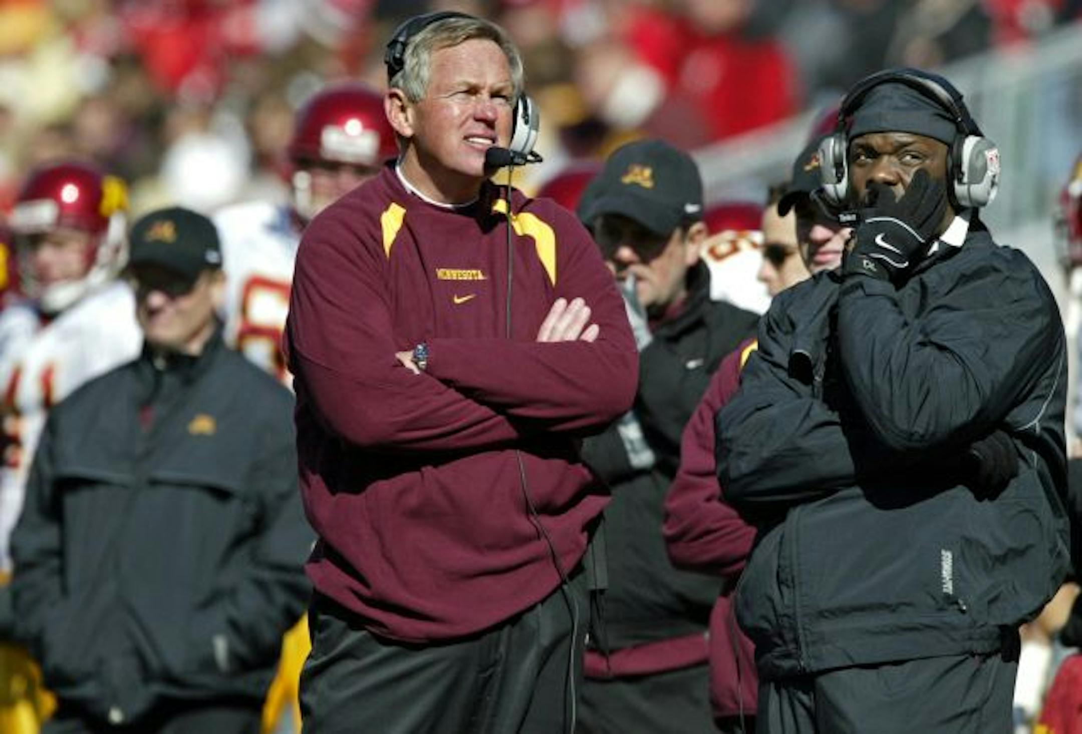 Head coach Glen Mason, left and defensive coordinator David Lockwood can do little but glance at the scoreboard late in the game as Wisconsin offense puts the game out of reach.