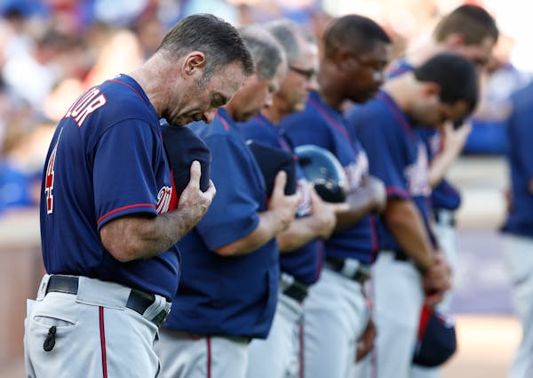 Members of the Minnesota Twins including manager Paul Molitor observe a moment of silence in remembrance of the officers killed and injured in Dallas.