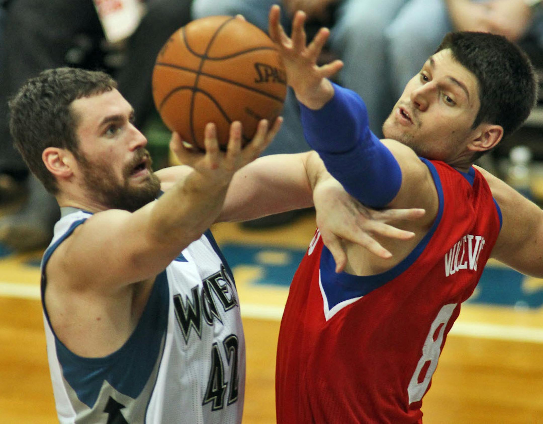 Wolves forward Kevin Love shot over Philadelphia's Nik Vucevik on Sunday.