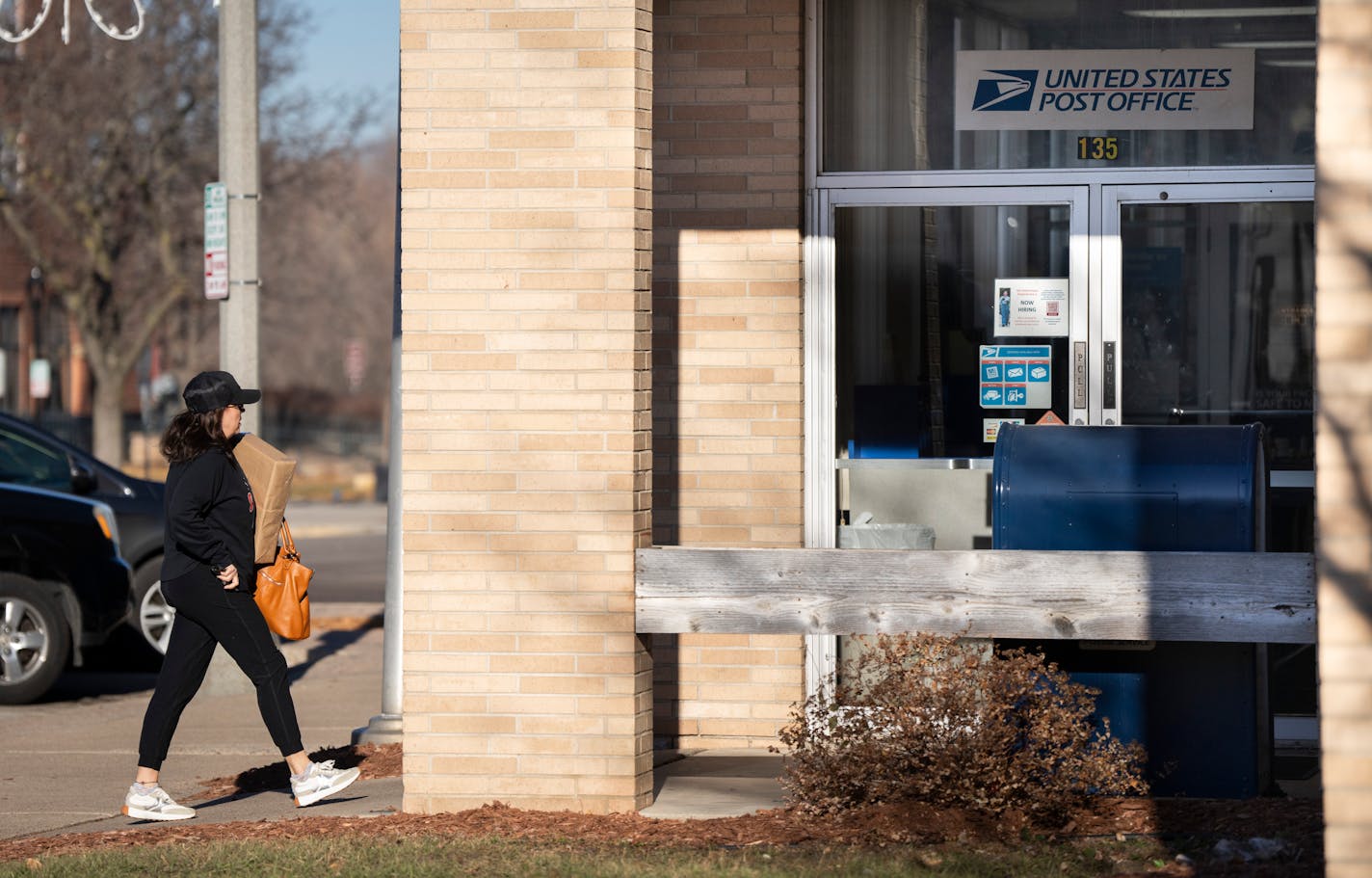 Emily Sell carries a Christmas package in to the U.S Post Office to ship on Thursday, Dec. 7, 2023 in downtown Shakopee, Minn. ] RENEE JONES SCHNEIDER • renee.jones@startribune.com