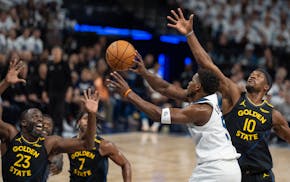 Timberwolves guard Anthony Edwards passes the ball while pressured by Golden State's Draymond Green (23) and forward Jimmy Butler (10) in the first qu