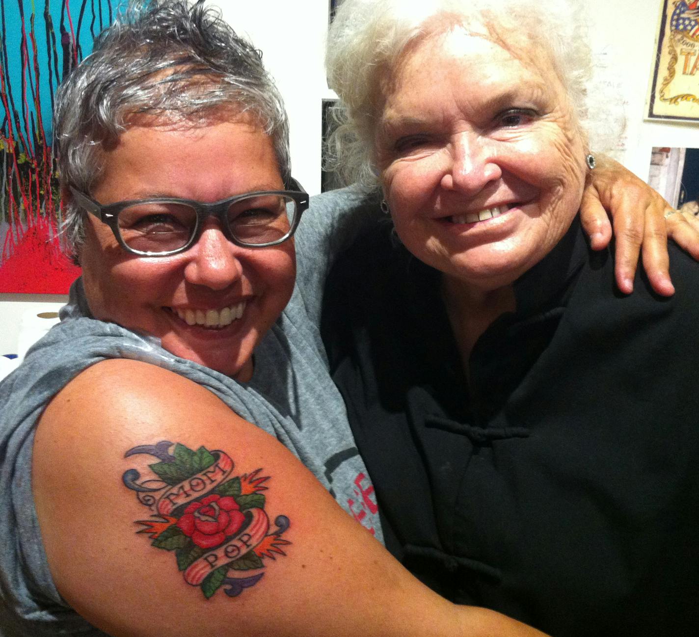 Tattoo pioneer Shanghai Kate Hellenbrand is notably the first woman of the modern era of tattooing and has the longest continuous career of any high-level tattoo artist in the United States. Image of Kate after tatooing a customer, Deb.