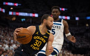 Golden State Warriors guard Stephen Curry (30) drives towards the basket while defended by Timberwolves guard Anthony Edwards (5) in the first quarter