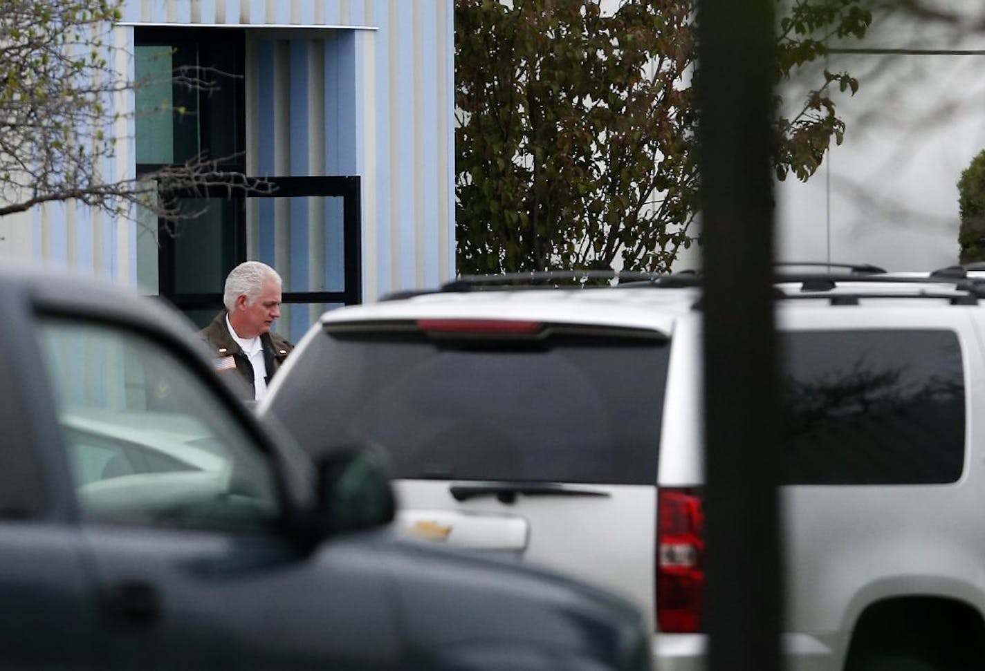 A law enforcement officer walked out of a door at Paisley Park on Tuesday. About a half-dozen unmarked cars were parked there as investigators returned to the complex.