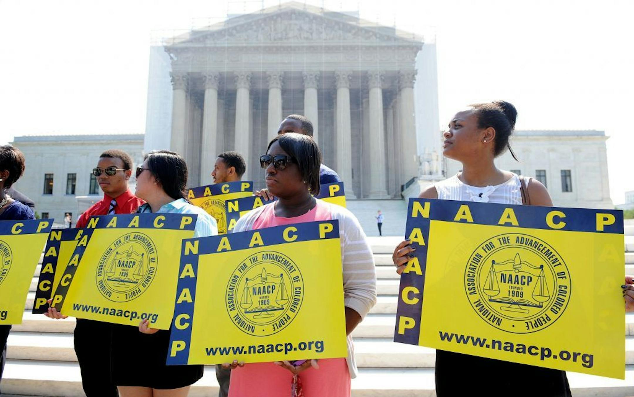 Demonstrators stand outside the U.S. Supreme Court on Tuesday, June 25, 2013, in Washingto, DC, the day the court ruled on the Voting Rights Act striking down portions of the law.