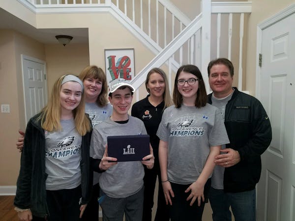 The Fitzgerald family and Mary Serie of Minnesota's Spare Key pose with the Super Bowl tickets given to Cole, center, in the Fitzgerald family home on