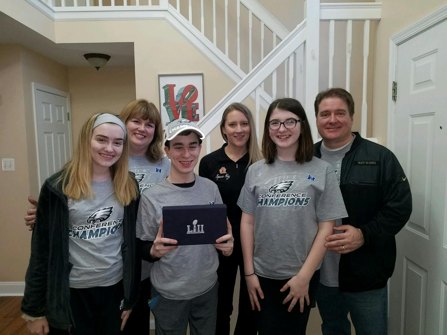 The Fitzgerald family and Mary Serie of Minnesota's Spare Key pose with the Super Bowl tickets given to Cole, center, in the Fitzgerald family home on Monday.