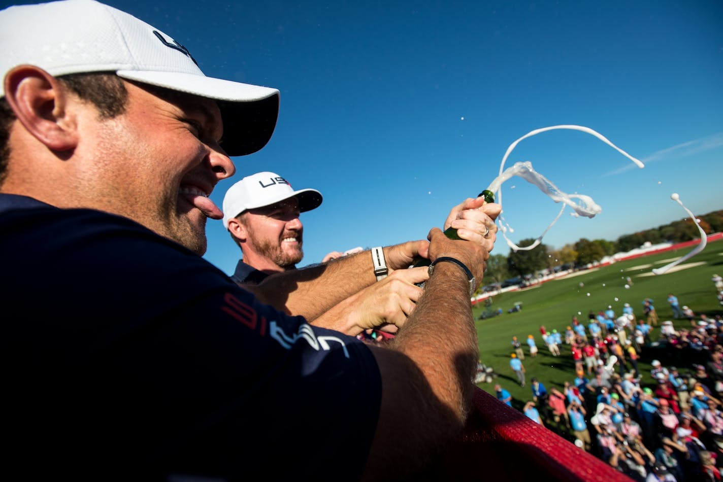 USA's Patrick Reed, left, and Dustin Johnson popped a bottle of champagne over fans while celebrating their Ryder Cup victory over Europe Sunday afternoon.