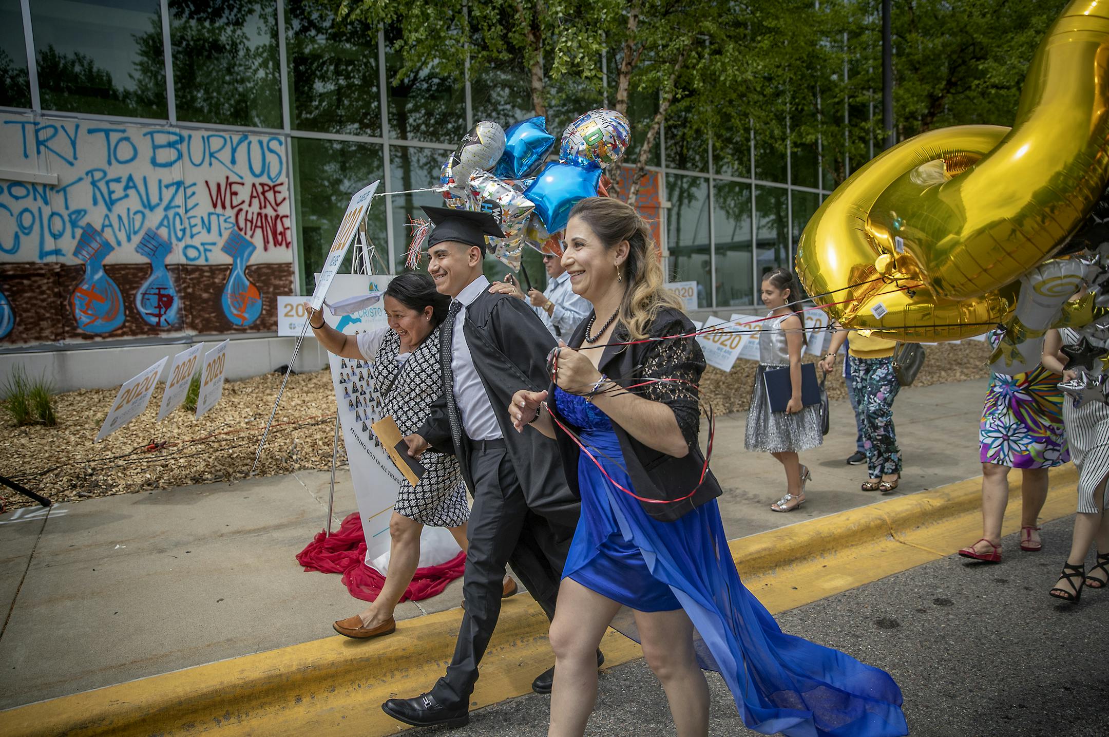 Cristo Rey Jesuit High School graduate Brian Fernandez walked to grab his diploma surrounded by his family during their drive-thru commencement celebration, Saturday, June 6, 2020 in Minneapolis, MN. The school, located in the heart of the unrest, only had four windows broken. Cristo Rey graduated a class of 124. ] ELIZABETH FLORES • liz.flores@startribune.com