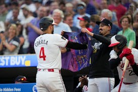 The Twins' Carlos Correa slips into a Prince-themed vest after hitting a two-run home run in the seventh inning of Minnesota's 6-2 victory over Oaklan