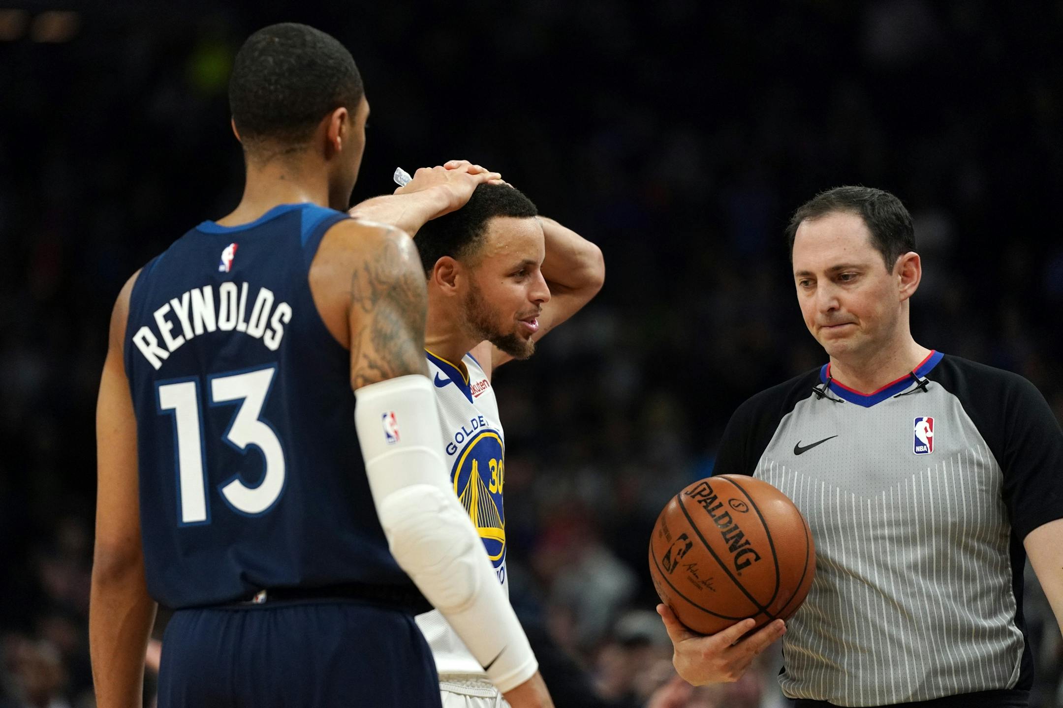 Golden State Warriors guard Stephen Curry (30) argued a foul with an official as Minnesota Timberwolves guard Cameron Reynolds (13) looked on in overtime.