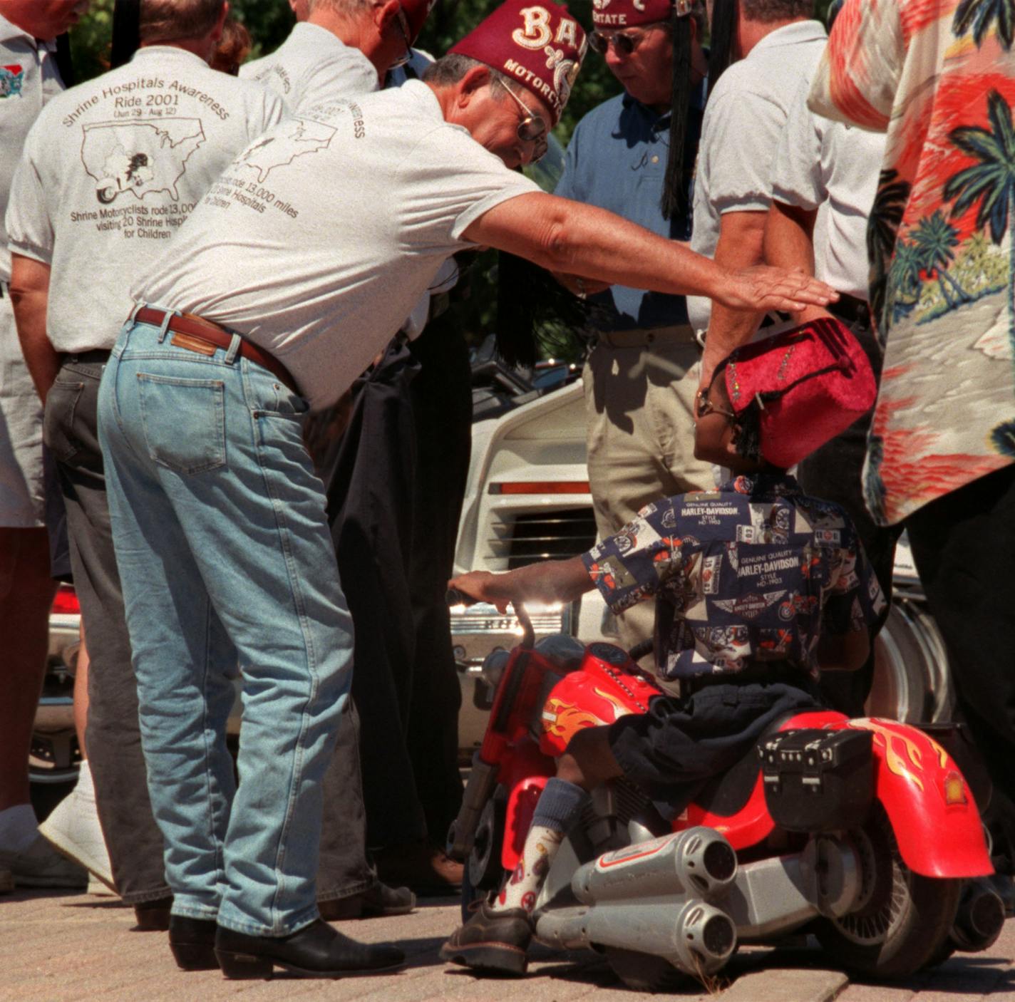 GENERAL INFORMATION: Shrine motorcycle riders are riding across the country to raise awareness about Shriners Hospitals for Children.
IN THIS PHOTO: Minneapolis, Mn., Weds., July 25, 2001--(Left to right) Don Anderson, one of the Shrine motorcycle riders who is travelling across the United States and Canada to raise awareness for Shriners Hospitals for Children, compliments seven-year-old Mark Braun on his fez (which his mom made). Braun, a patient at Shriners Hospitals for Children is from Moun