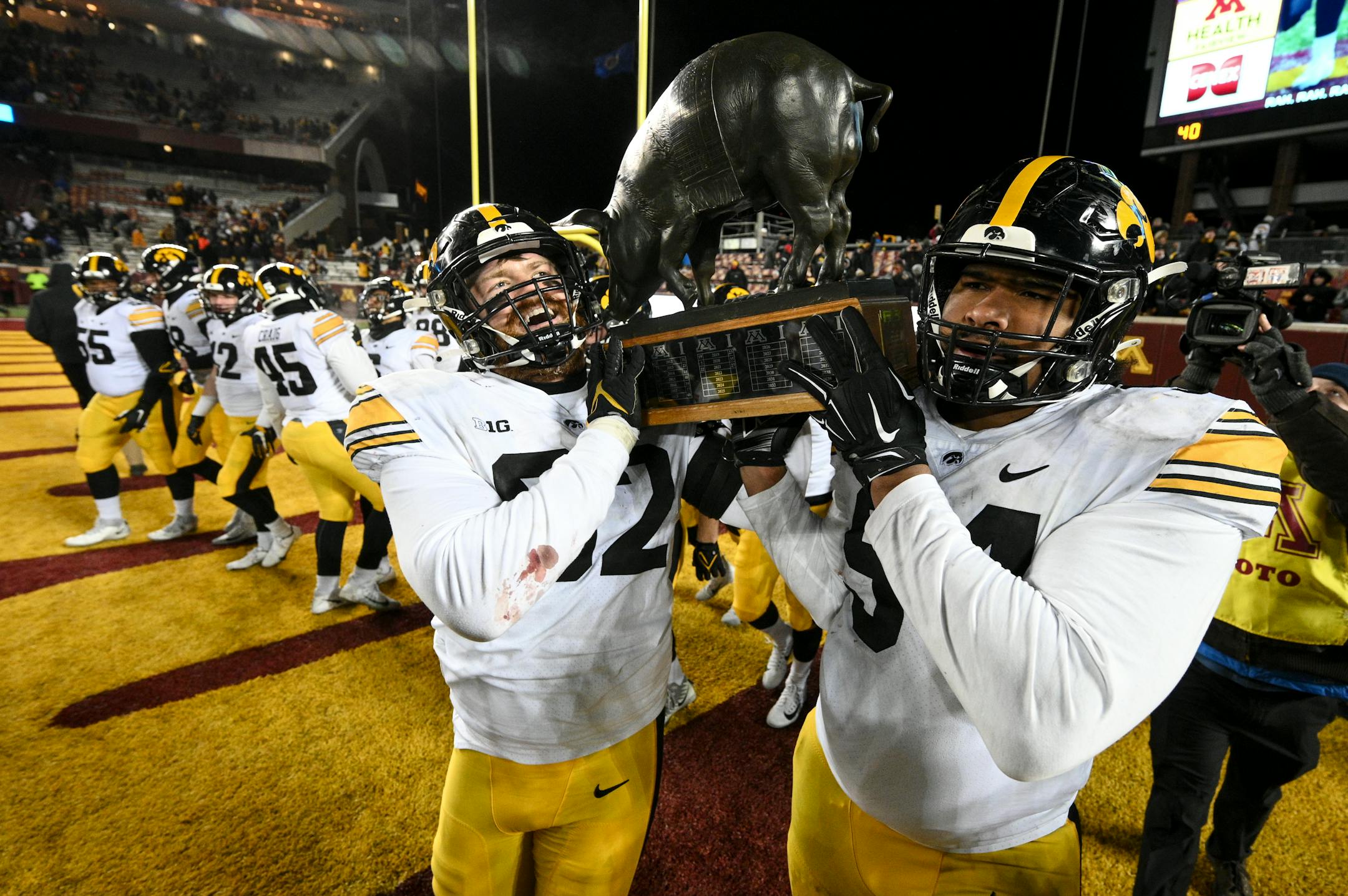 Iowa Hawkeyes defensive lineman John Waggoner (92) and defensive lineman Yahya Black (94) hoist the Floyd trophy over their shoulders after defeating the Minnesota Gophers 13-10.