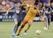 Minnesota United midfielder Ethan Finlay, left, is held back as Houston Dynamo defender Kevin Garcia, right, moves the ball during the first half of a