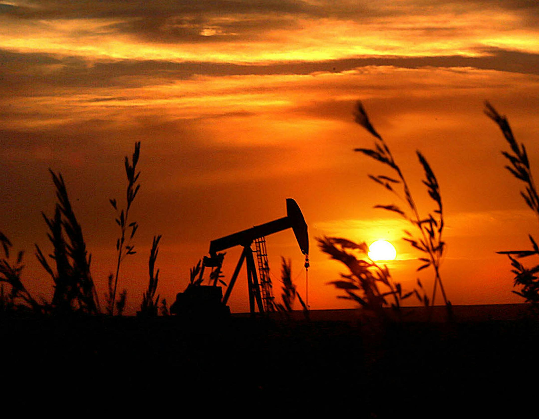 The sun set over the Bakken Oil Formation, behind an oil well near Williston. ] (JIM GEHRZ/STAR TRIBUNE) / September 26, 2013, Watford City, ND ‚Äì BACKGROUND INFORMATION- PHOTOS FOR USE IN FIRST PART OF NORTH DAKOTA OIL BOOM PROJECT: Dozens of drilling rigs dot the North Dakota landscape in the Williston Basin and the Bakken Oil Formation. Once the rigs drill holes, several miles deep and then several miles horizontally, hydraulic fracturing technology (‚Äúfrac