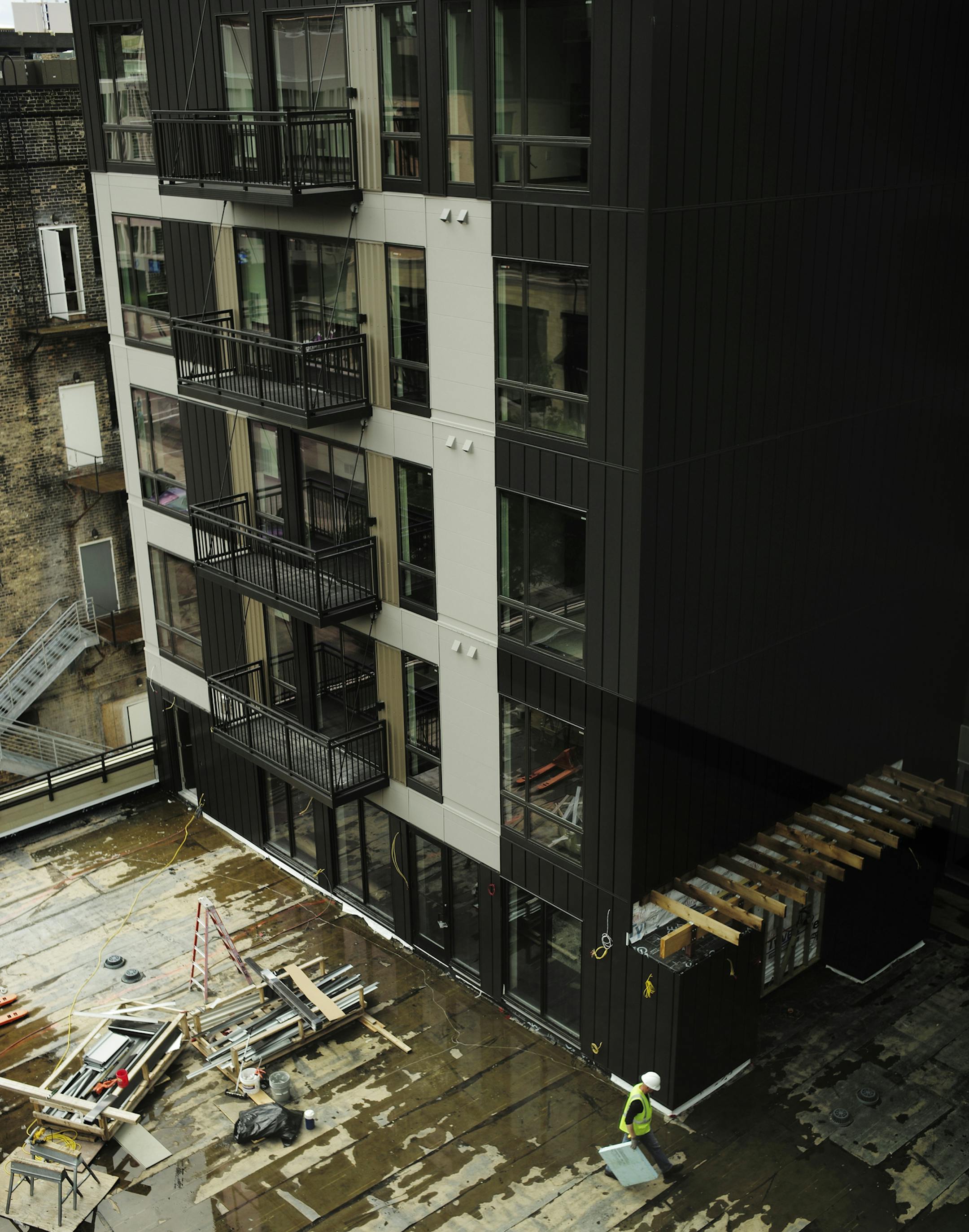 On July 15, 2014, at the Velo apartment complex nearing completion, Opus Director Project ManagemerTom Becker is saving his company tons of time and money by building big chunks of their buildings (such as huge exterior wall panels) at off-site factories, trucking them in and craning them into place rather than doing it all on-site. Thanks to advances in BIM (building information modeling) these prefab pieces are becoming the industry standard during this recent building boom. . ]rtsong-taatarii