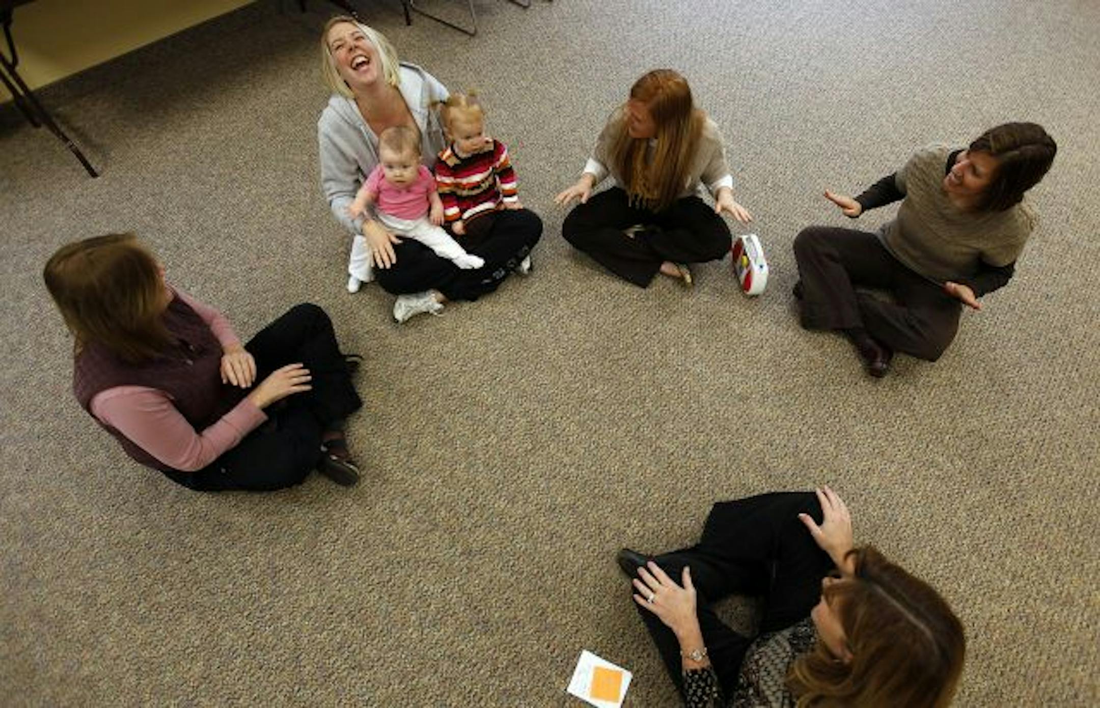 Amber Lueders, of Ramsey laughed as she held her daughter Leila, (in pink) and Lily Van Hecke, with Lily's mother Jennifer next to them on right (red hair). Both women have husbands in the military.