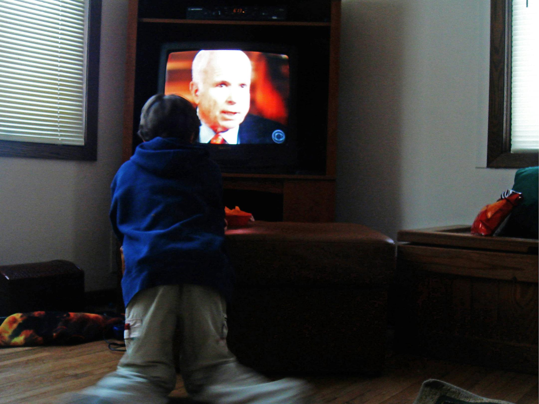 "Pray," Tim White's photo of a child watching presidential candidate John McCain on television, evokes the endless invasiveness of the 2008 political season.