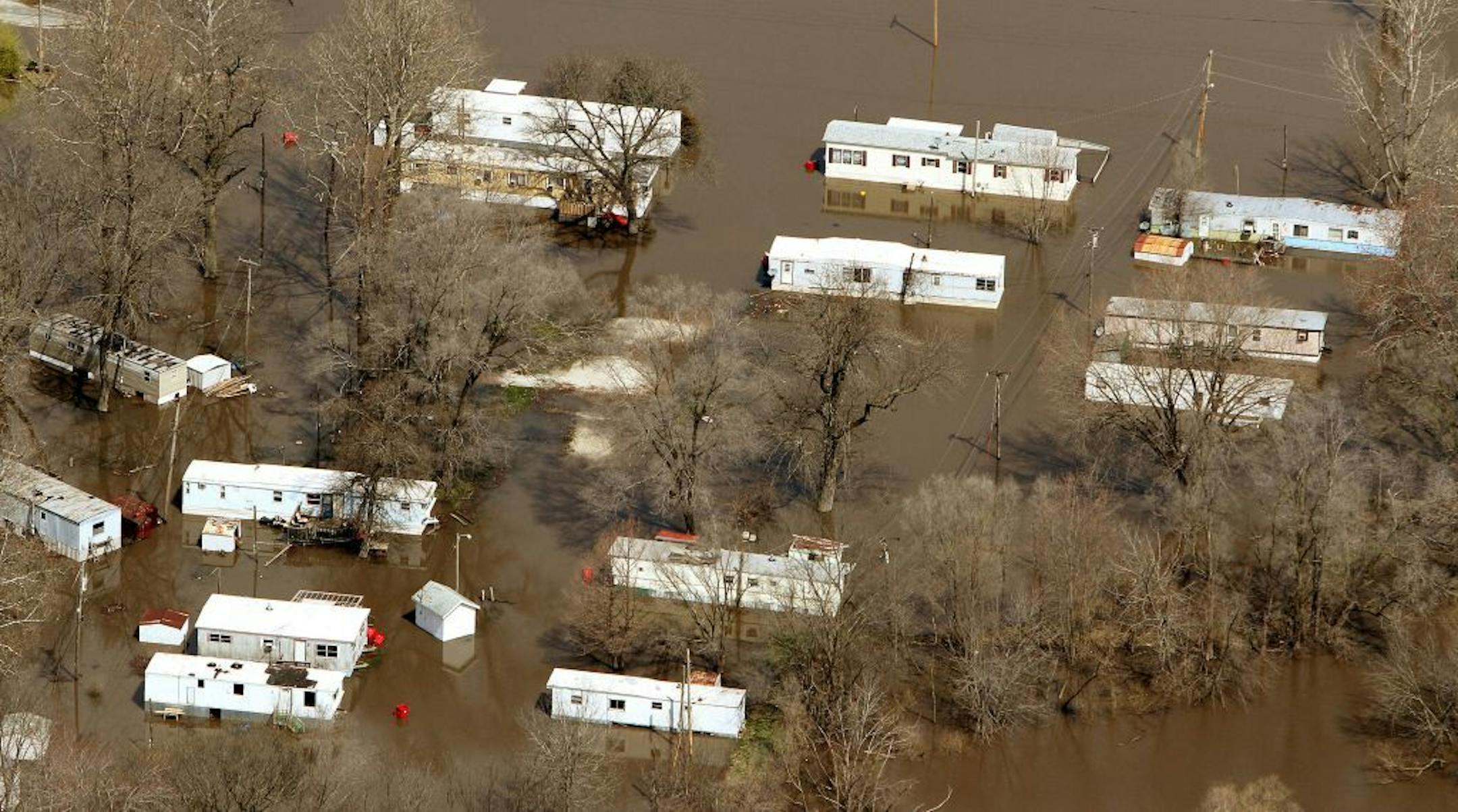 Flood waters from the Rock River surround homes on Barstow Road Monday April 22, 2013, over Barstow, Ill. A slow-moving spring storm is bringing much-needed moisture to parts of the Rockies and the Plains, but winds are raising the wildfire danger to the south.