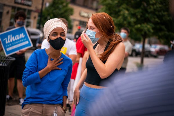 Rep. Ilhan Omar, left, D-Minn., talked with Keaton Sisk outside the Dinkytown Target near the University of Minnesota campus in Minneapolis on Tuesday