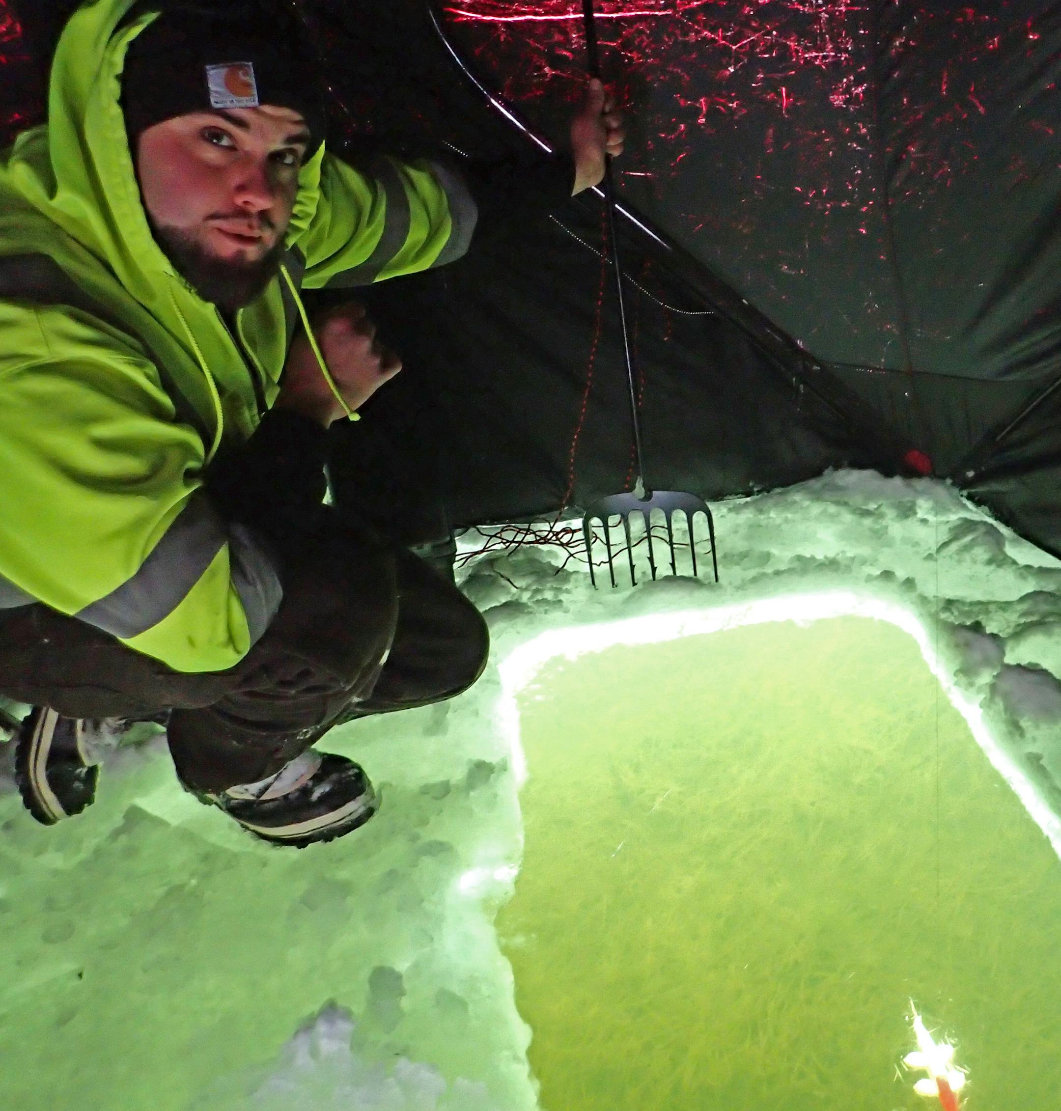A waiting game: Justin Barnhart of Stillwater hoped a northern pike would swim by his spearing hole on Lake Demontreville.