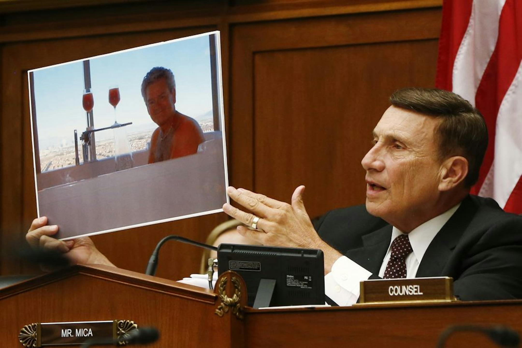 House Oversight and Government Reform Committee member Rep. John Mica, R-Fla., holds up a picture of a GSA employee in a hot tub as he questions witnesses on Capitol Hill in Washington, Thursday, June 6, 2013, during the committee's hearing regarding IRS conference spending.