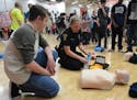 Alex Rasmussen, a sophomore at Coon Rapids High School, received instruction in using a defibrillator from Brianna Johnson, of the Coon Rapids Police 