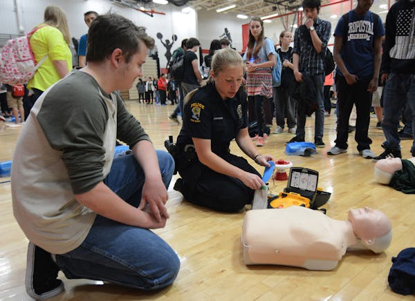 Alex Rasmussen, a sophomore at Coon Rapids High School, received instruction in using a defibrillator from Brianna Johnson, of the Coon Rapids Police 